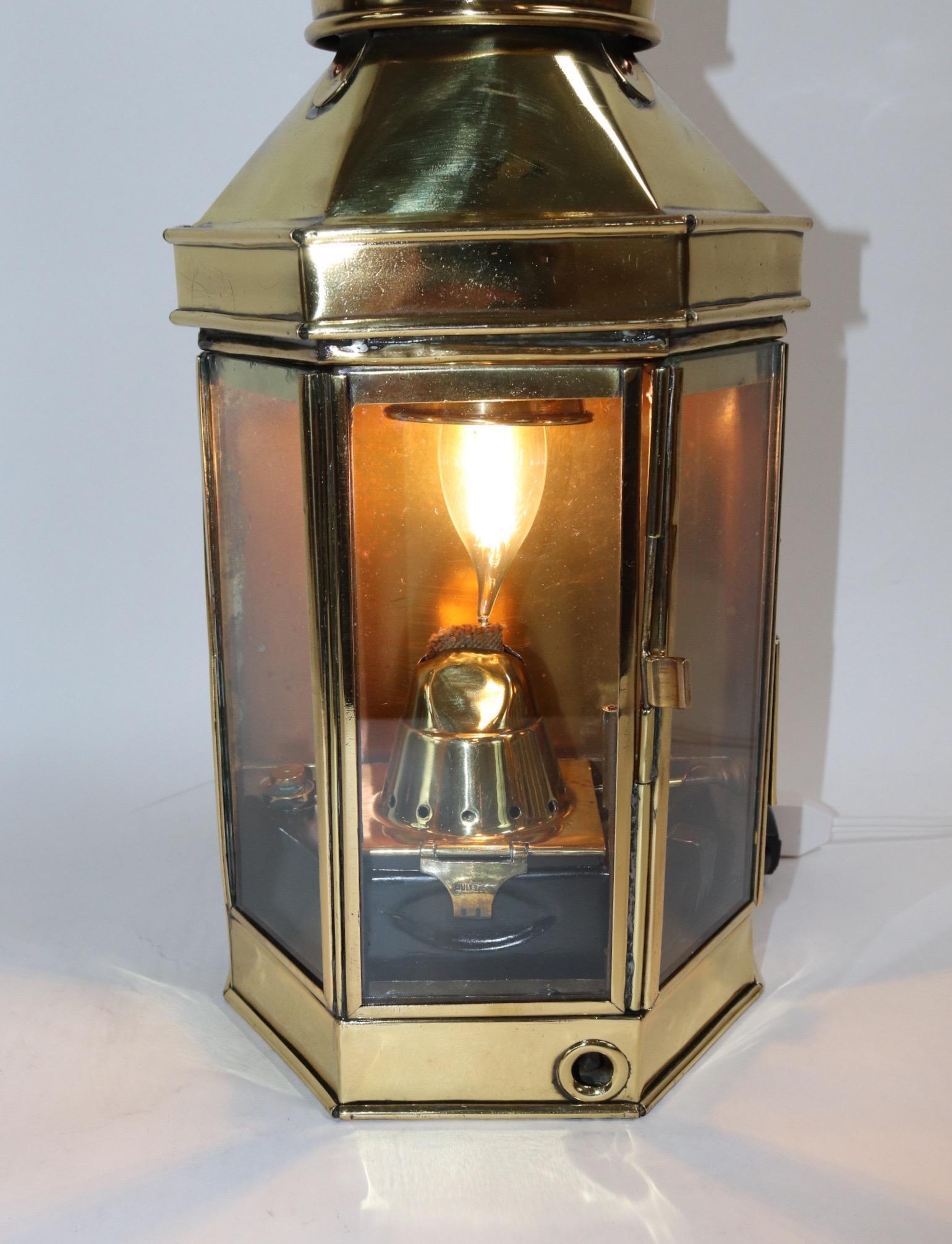 Solid brass yacht cabin lantern by English maker Bulpitt, dated 1942. With original burner, wood carry handle, hinged door, and wired for home display. Lantern has been meticulously polished and lacquered.

Overall dimensions: 16