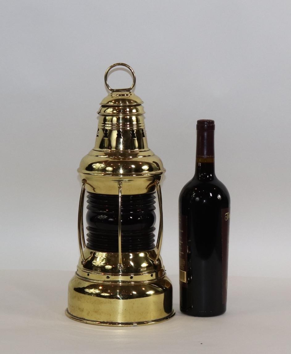 Polished brass ships lantern with large reserve oil tank by Perko. With red glass Fresnel lens that has protective brass bars, vented top, burner, etc. Weight is 5 pounds.