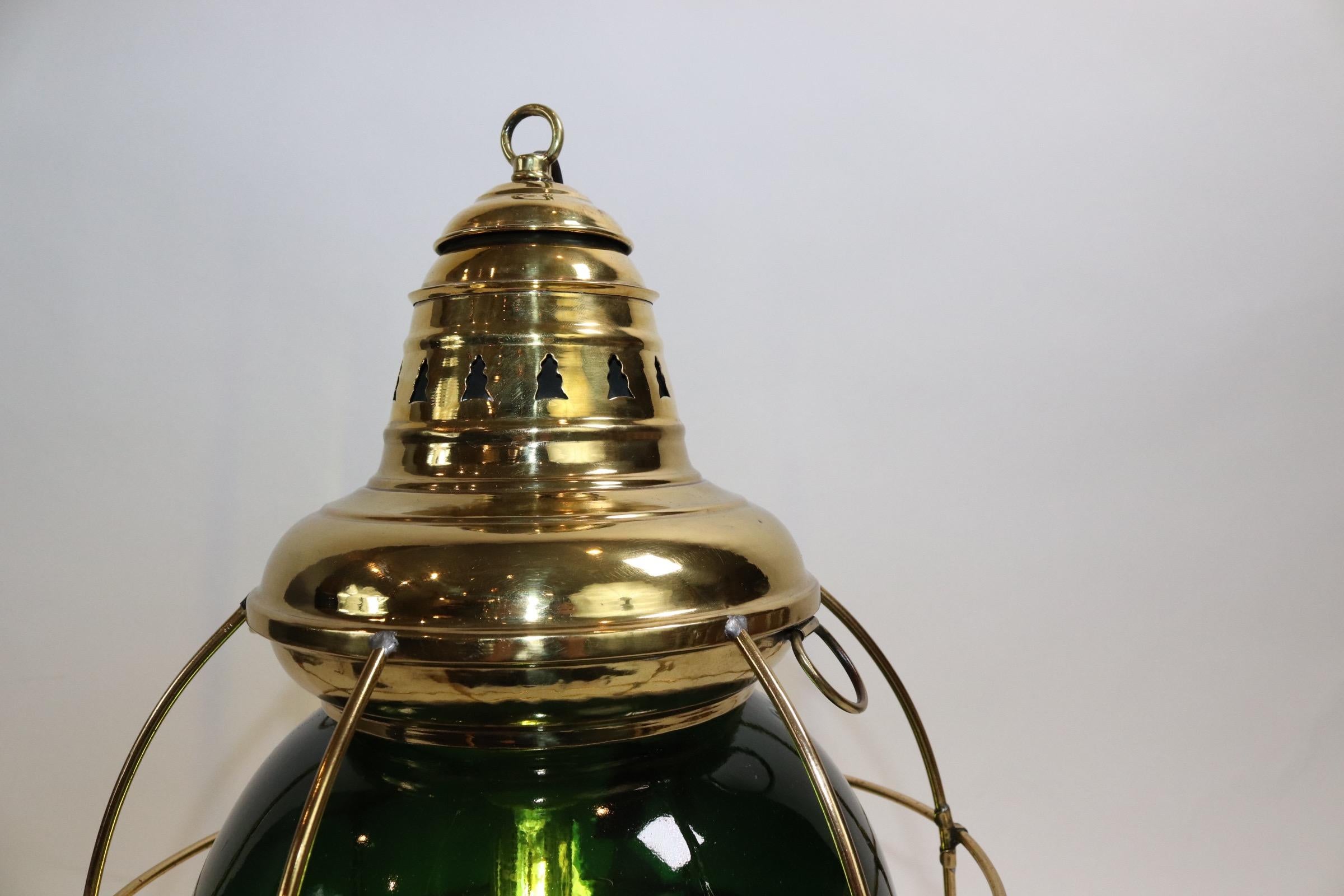 Solid brass ships onion lantern with green lens. Highly polished and lacquered. Wired with electricity for home display. Fitted with a protective brass cage and ten inch dark green lens marked Perkins. Weight is 7 pounds.