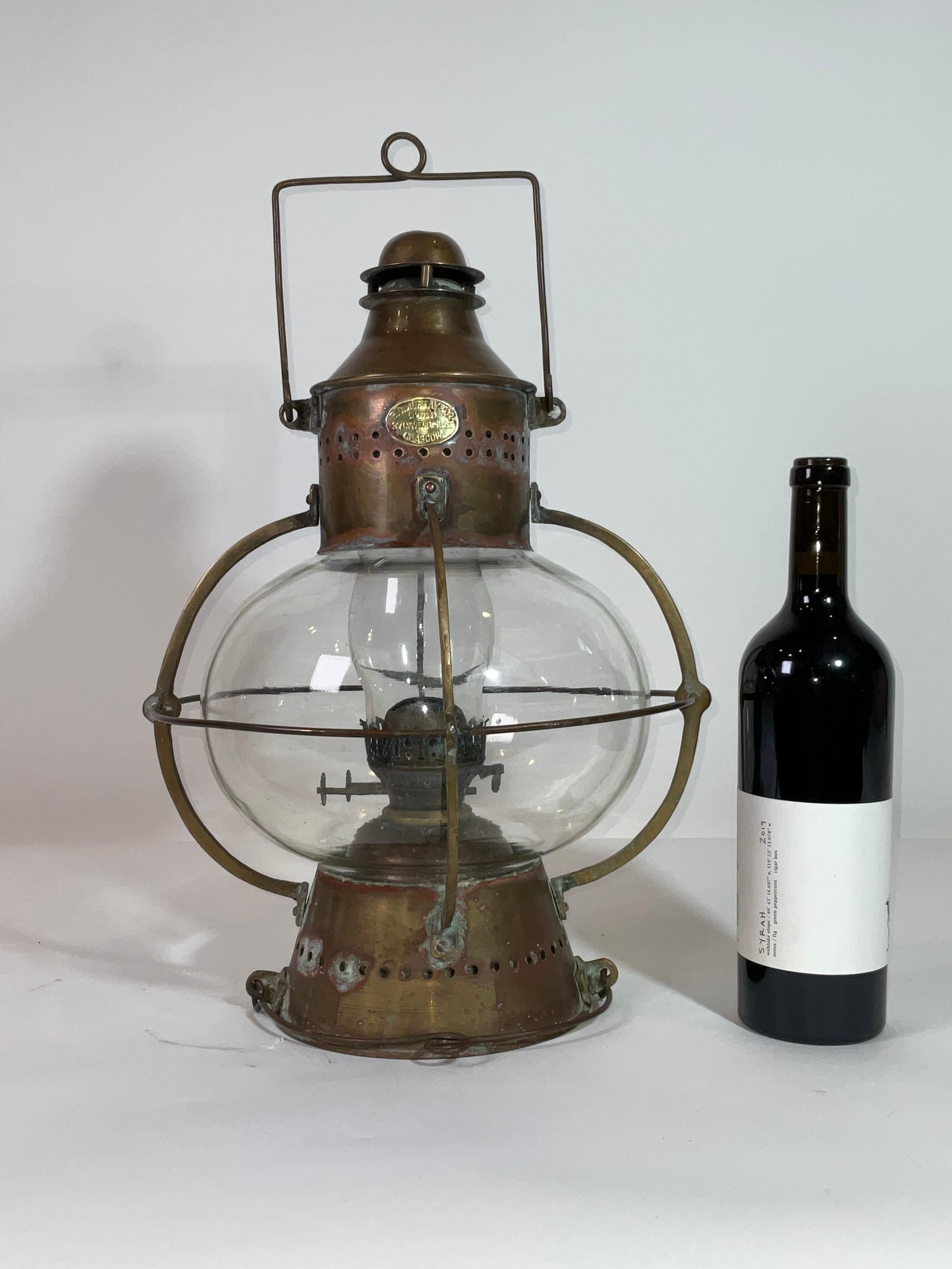 Large size glass globe onion lamp from a ship well made european style oil lantern with original burner and chimney shade. The Glass globe is protected by Brass bars. There is a vented chimney and cap with its original weathered finish.

Weight:   