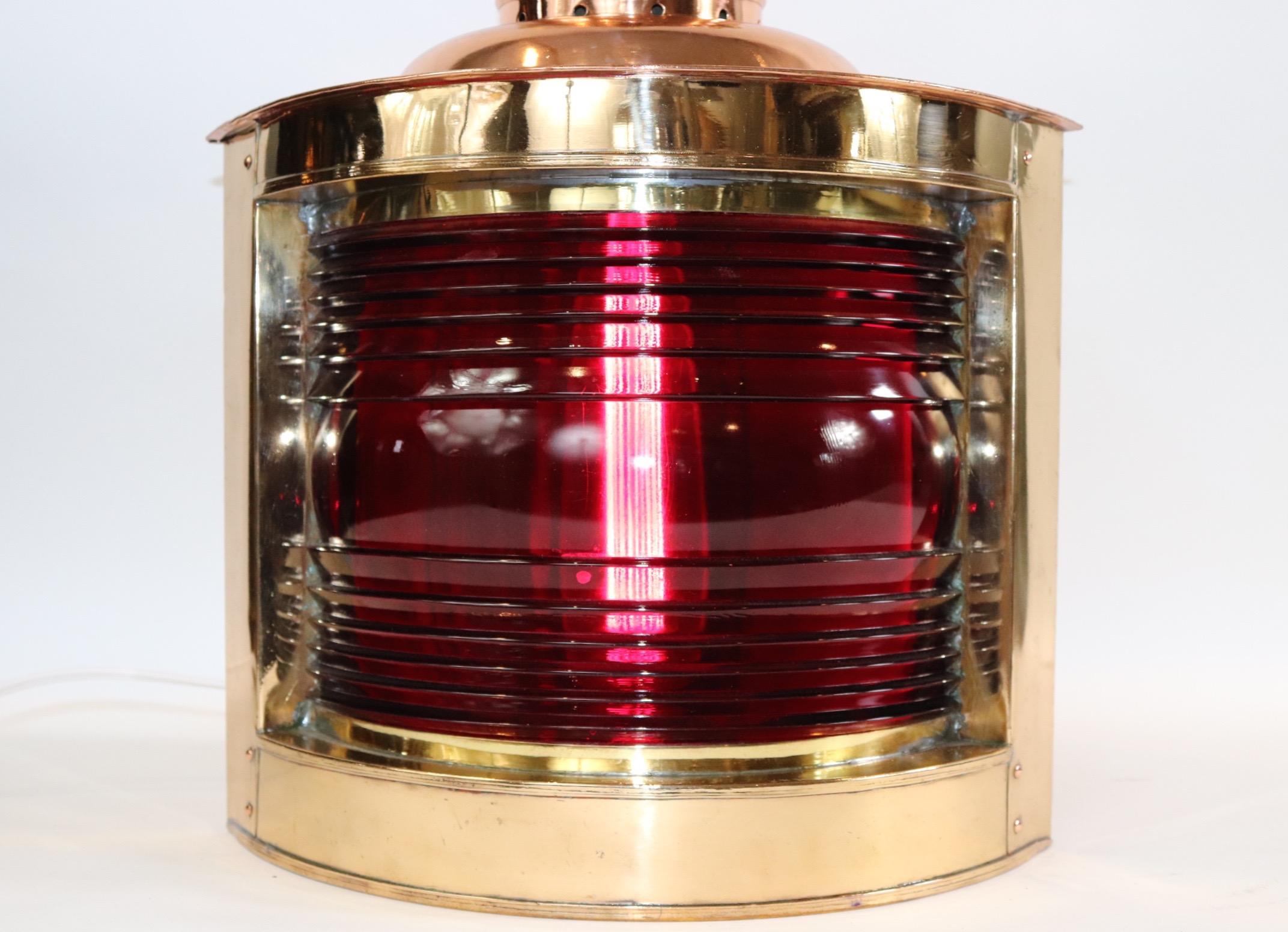 Solid brass ships port lantern with deep red fresnel lens set into a highly polished and lacquered case. Lantern has been wired with electric socket for home use. Weight is 16 pounds.