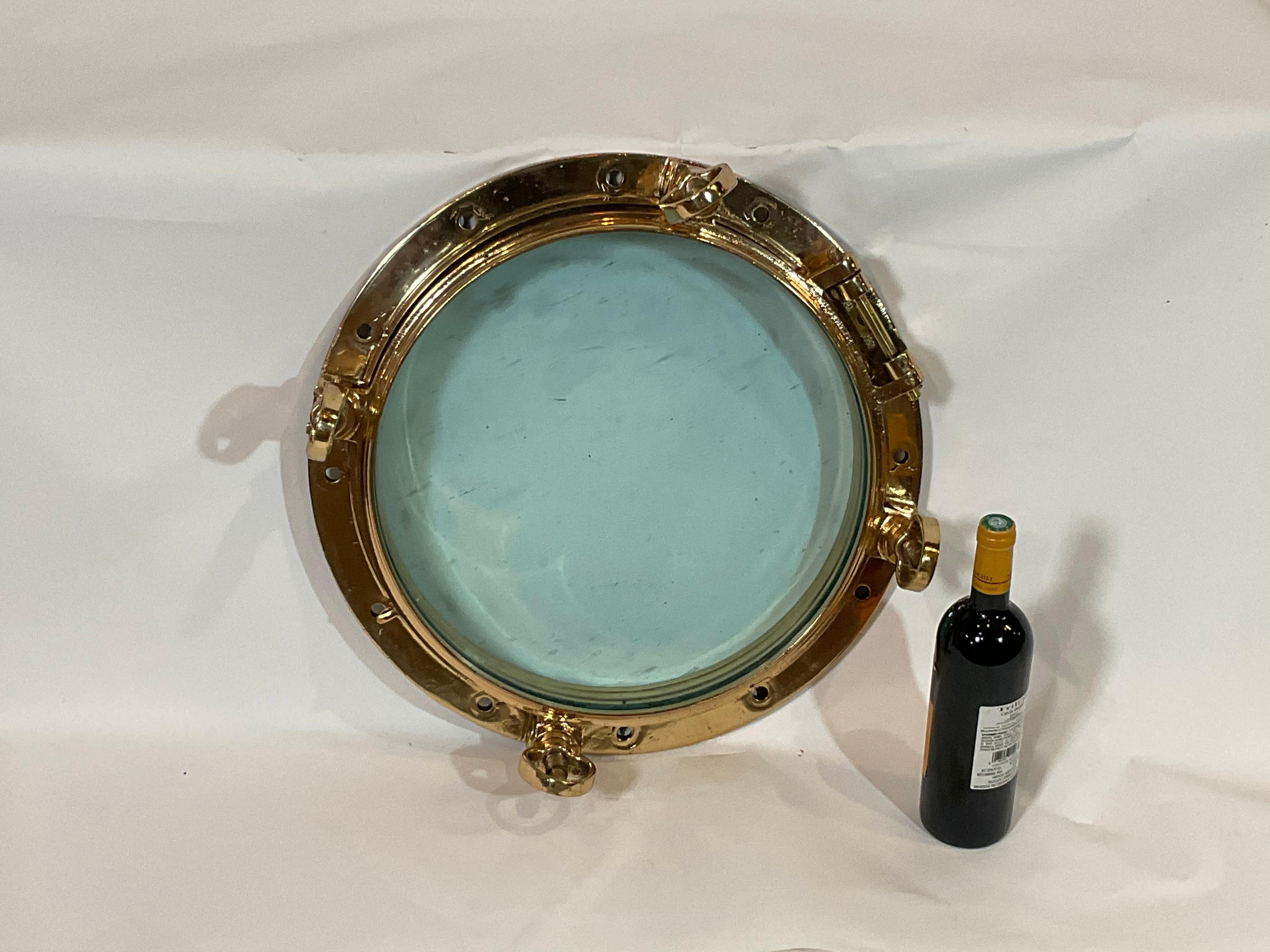 Highly polished ships porthole with hinged door and four dog bolts. Meticulously polished and lacquered. The tempered glass has some imperfections from years at sea. Large in size. Forty-seven pounds. 

Weight: 47 LBS
Overall Dimensions: 6”