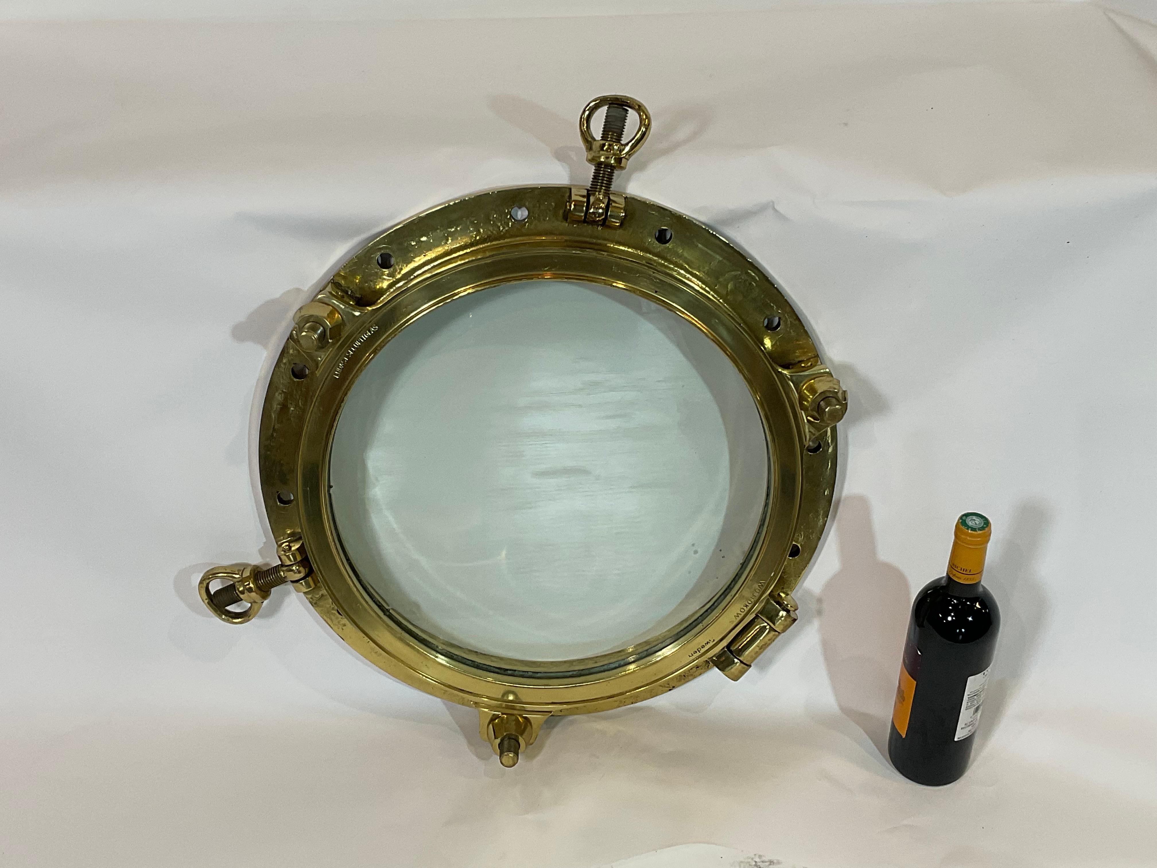 Highly polished ships porthole with clear lacquer finish. Hinged door with five bolts. Ring is engraved Endast Securitglas, Wojidkows, Sweden. Quality piece.

Weight: 51 LBS.
Overall dimensions: 5” height x 21” diameter.
Made: Sweden.
Material: