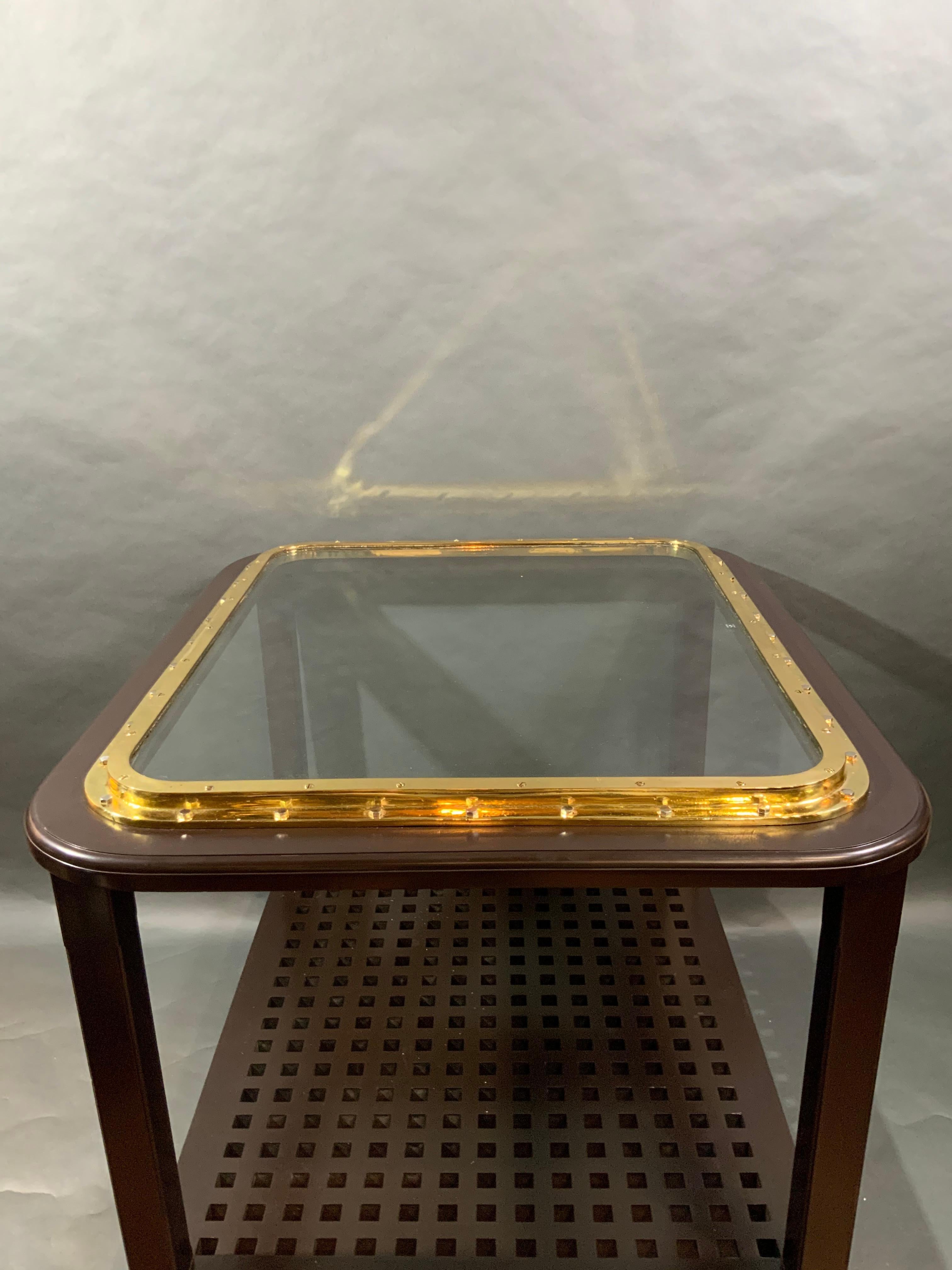 Very nice solid brass ships porthole that has been meticulously polished and lacquered and mounted to a counter height table. This table is suitable for two to four barstools. Also a great computer table or bar table. With ship's grating shelf