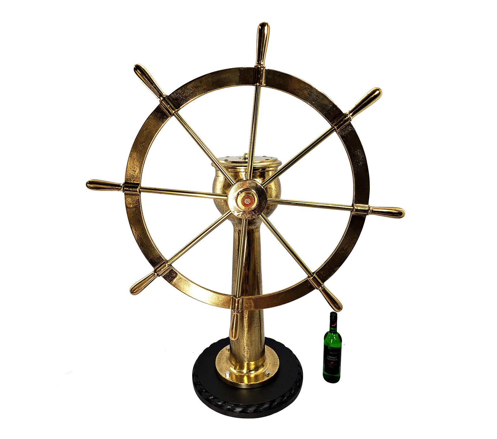 Very impressive eight spoke ships wheel mounted to a geared pedestal. The pedestal head is engraved Dake Engine Company, Grand Haven Michigan, serial number 6770 with rudder indicator arrow. Entire unit has been meticulously polished and lacquered.