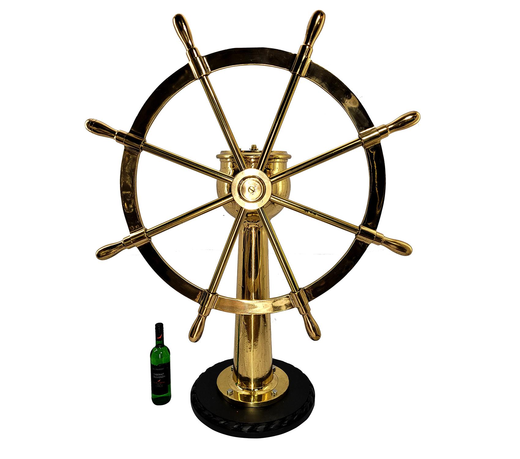 Very impressive eight spoke ships wheel mounted to a geared pedestal. The pedestal head is engraved Dake Engine Company, Grand Haven Michigan, Serial number 7823 with rudder indicator arrow. Entire unit has been meticulously polished and lacquered.
