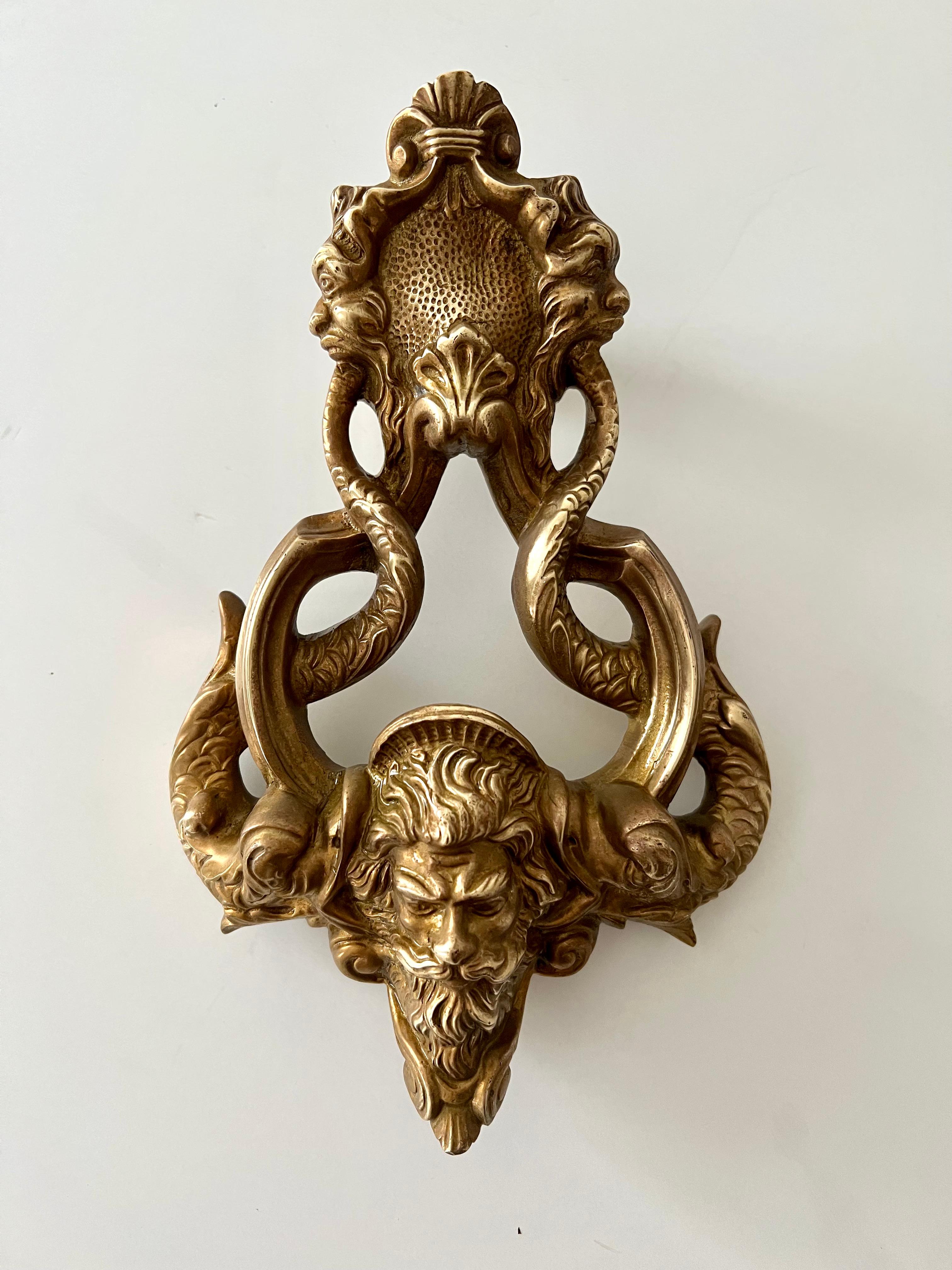 A wonderfully intricate Door knocker of solid brass. The piece is very detailed with faces and focal point of Zeus surrounded by Curved Dolphins - definitely a statement for your guests upon arrival - 

As the chief Greek deity, Zeus is considered