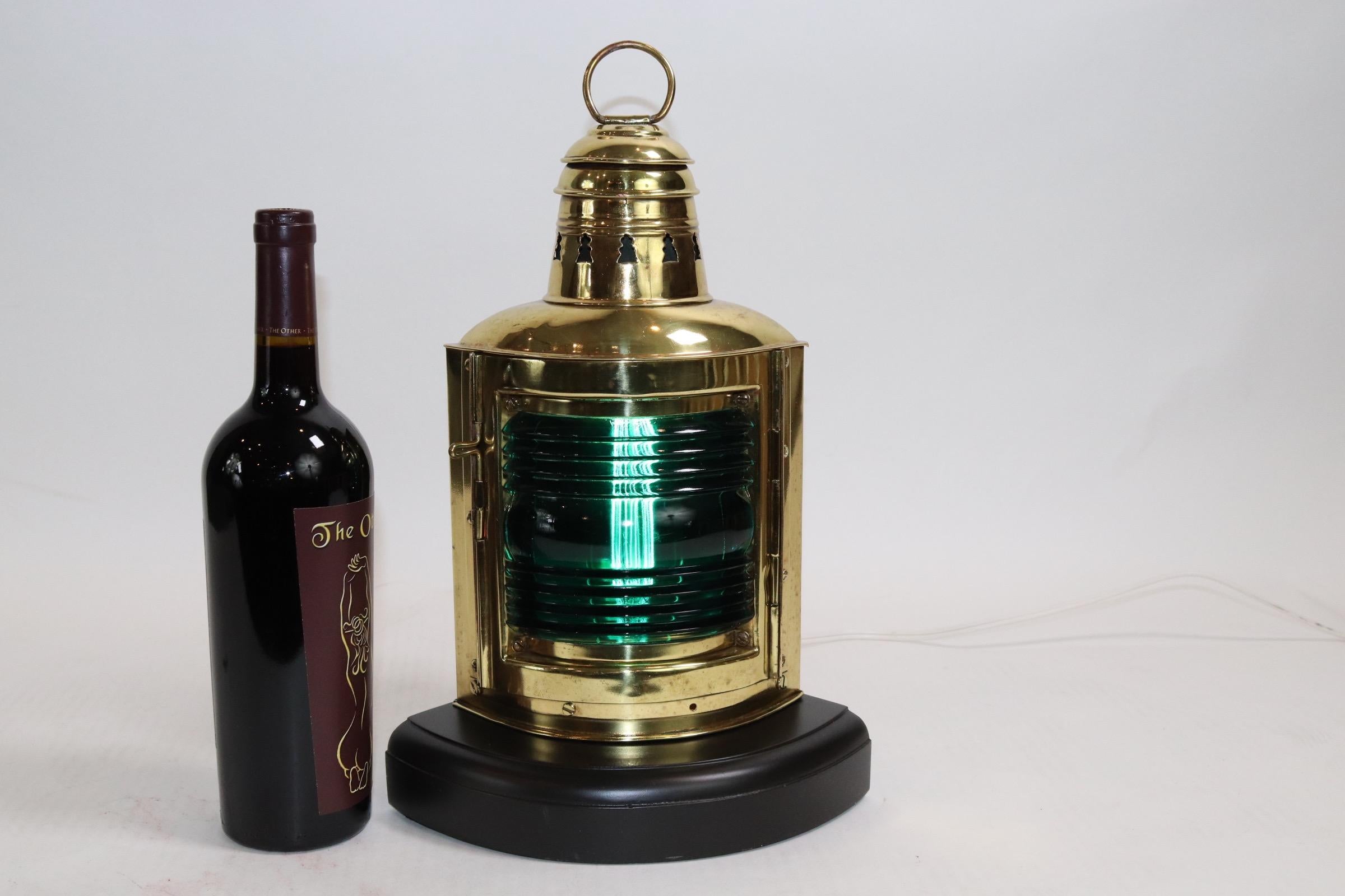 Highly polished solid brass starboard ships lantern with green Fresnel lens. This lantern has makers name Perko embossed on the rear. Mounted onto a thick wood base with electric socket installed for home display. Weight is 5 pounds.