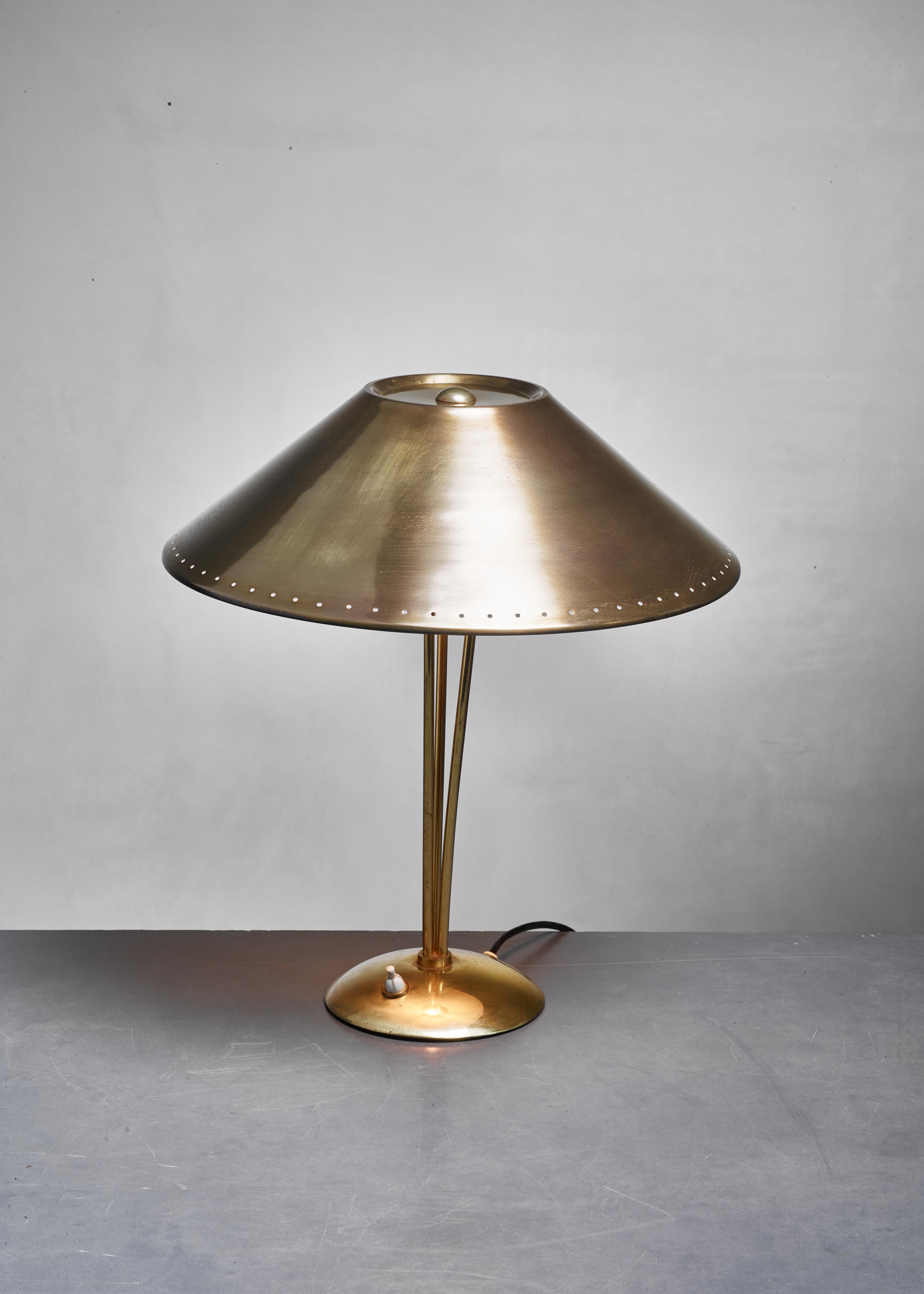 An elegant and simple solid brass table lamp with a beautiful mild aging. The inner side of the hood is off-white, giving a warm radiance.