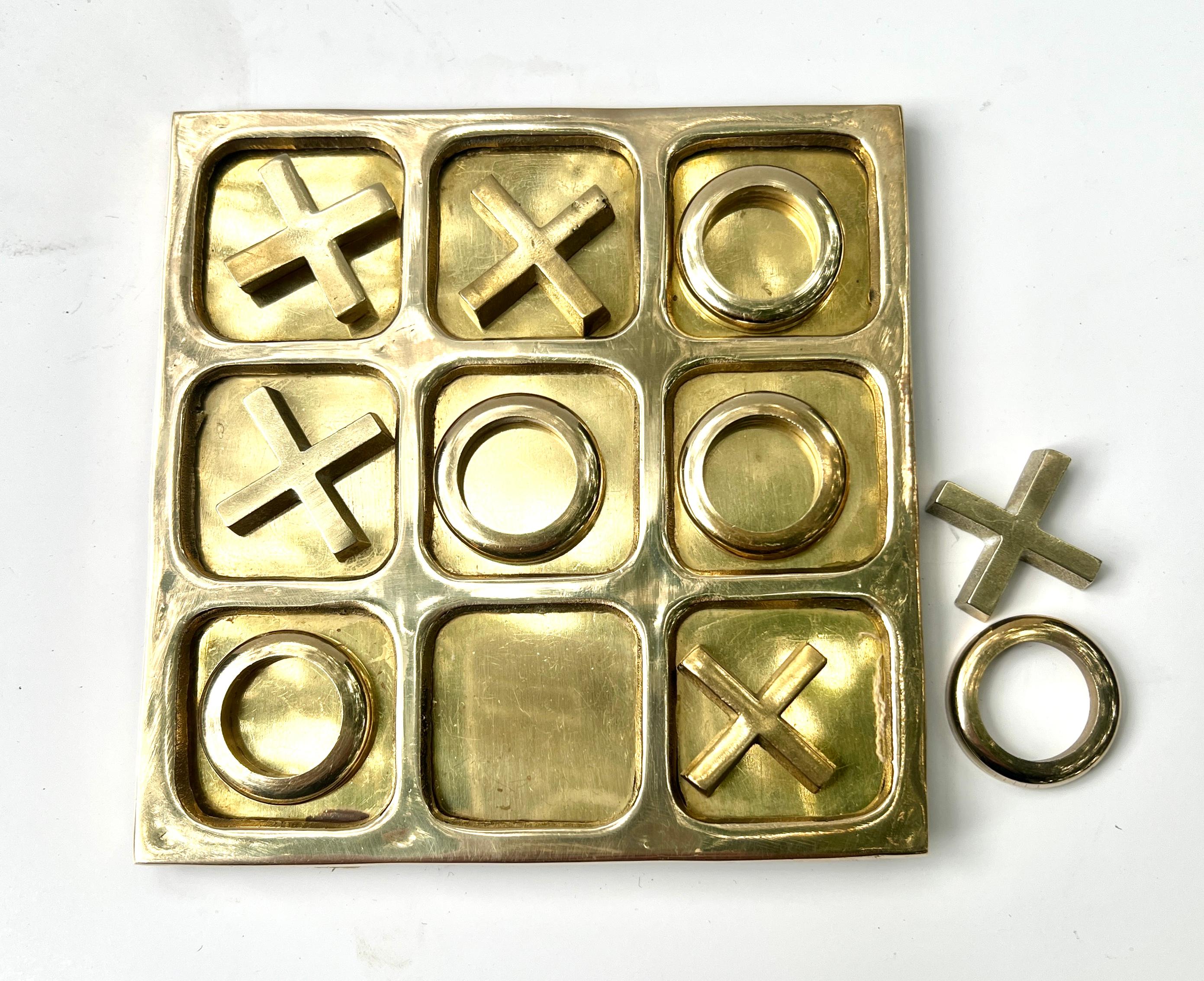Una splendida tavola da Tic Tac in ottone massiccio.  Un pezzo perfettamente progettato per giocare, ma ancora meglio, il pezzo può essere posizionato su una console, un tavolo da cocktail o un ottimo rompighiaccio per l'area bar.

Un pezzo