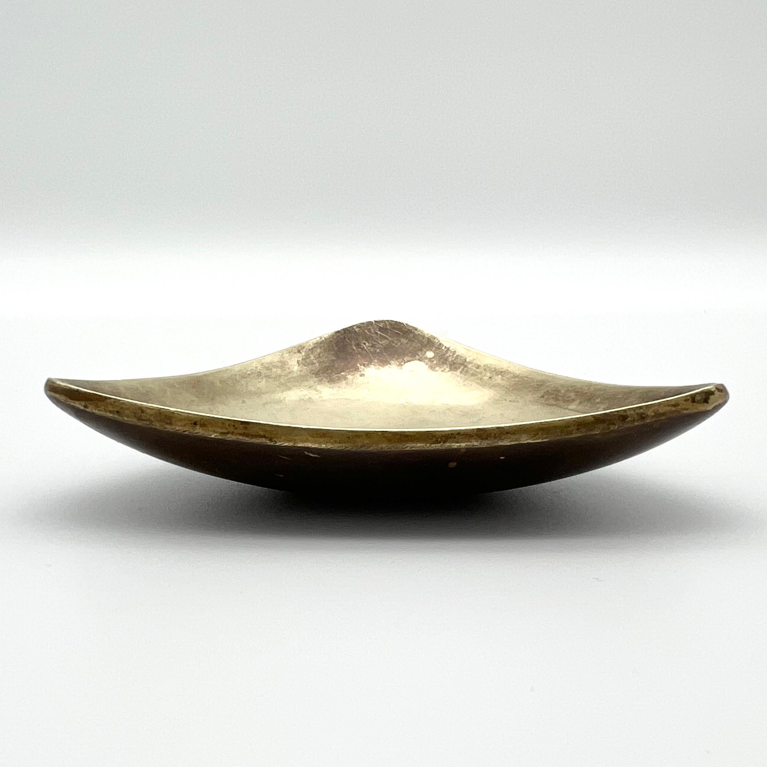Triangular Ashtray, made in the 1950s in Vienna. 
Made of Solid brass with a great patina built up over time.

Side lengths: 9,5cm
Height: 2cm

The design drawing is also pictured in the cataloge: 