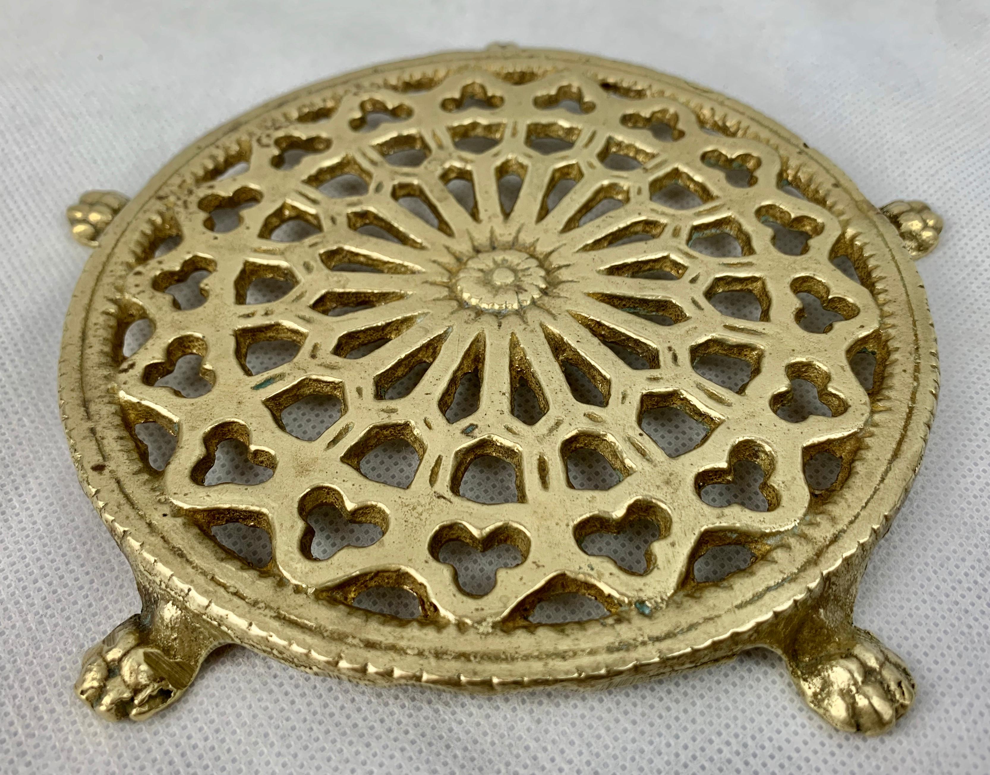 Victorian solid brass trivet with intricate pierced design. The trivet rests on five lion's paw feet and was originally used on a table to hold hot or cold items. Why not use it under a plant or under any item just to elevate and bring attention to