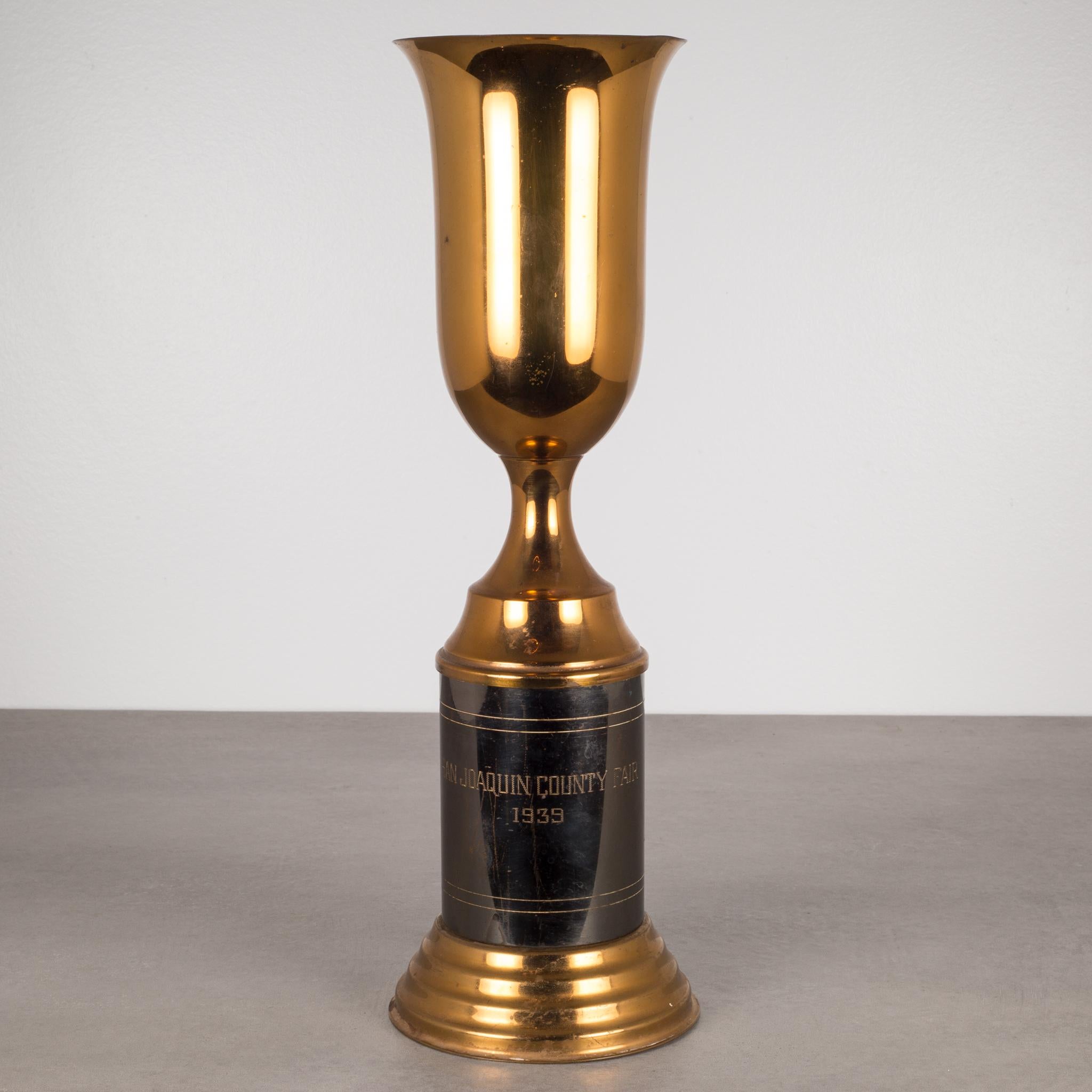 ABOUT

This is an original solid brass trophy cup from the San Joaquin County Fair, California USA, 1939. The large brass cup is mounted on pewter column that has been engraved 