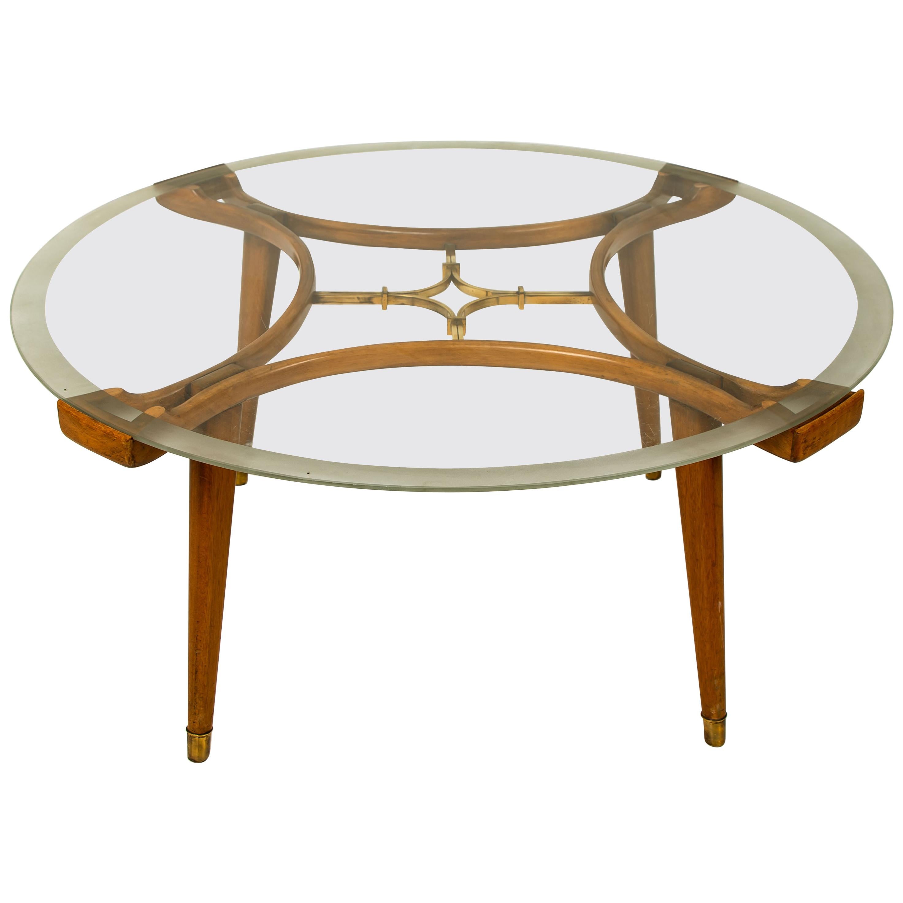 An original coffee table, designed by William Watting, produced by Fristho, the Netherlands, 1950s. A very special design due to the organic warm walnut wood combined with a transparent glass top. The center shows a beautiful solid brass detail.