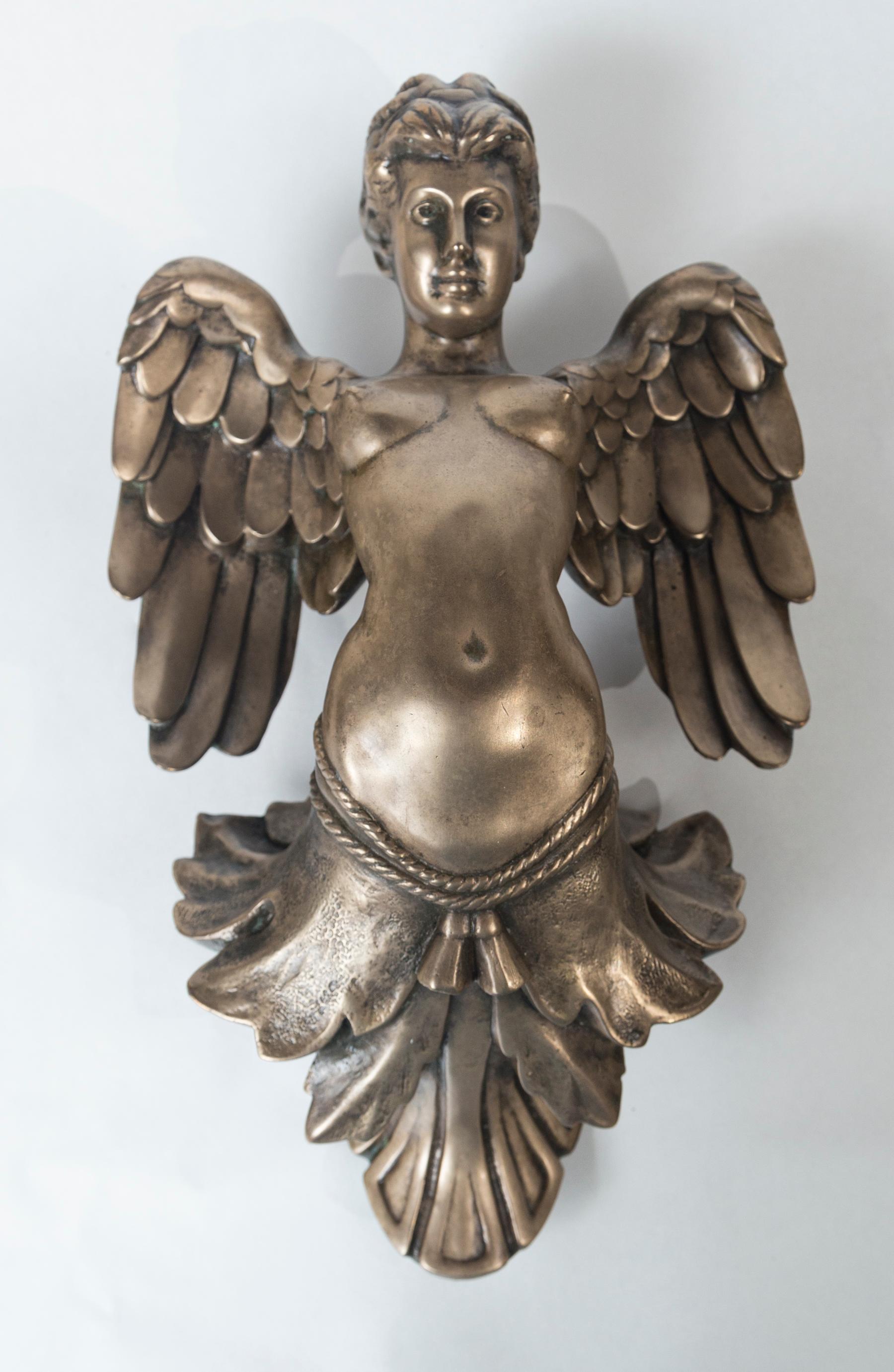 This female form, with wings, may have been part of a door knocker. It is signed on the back of the left wing MARK MILLER 1964, with a copyright circle and C and the letters AP. Polished surface.
The item has 3 bolts that would have secured it to