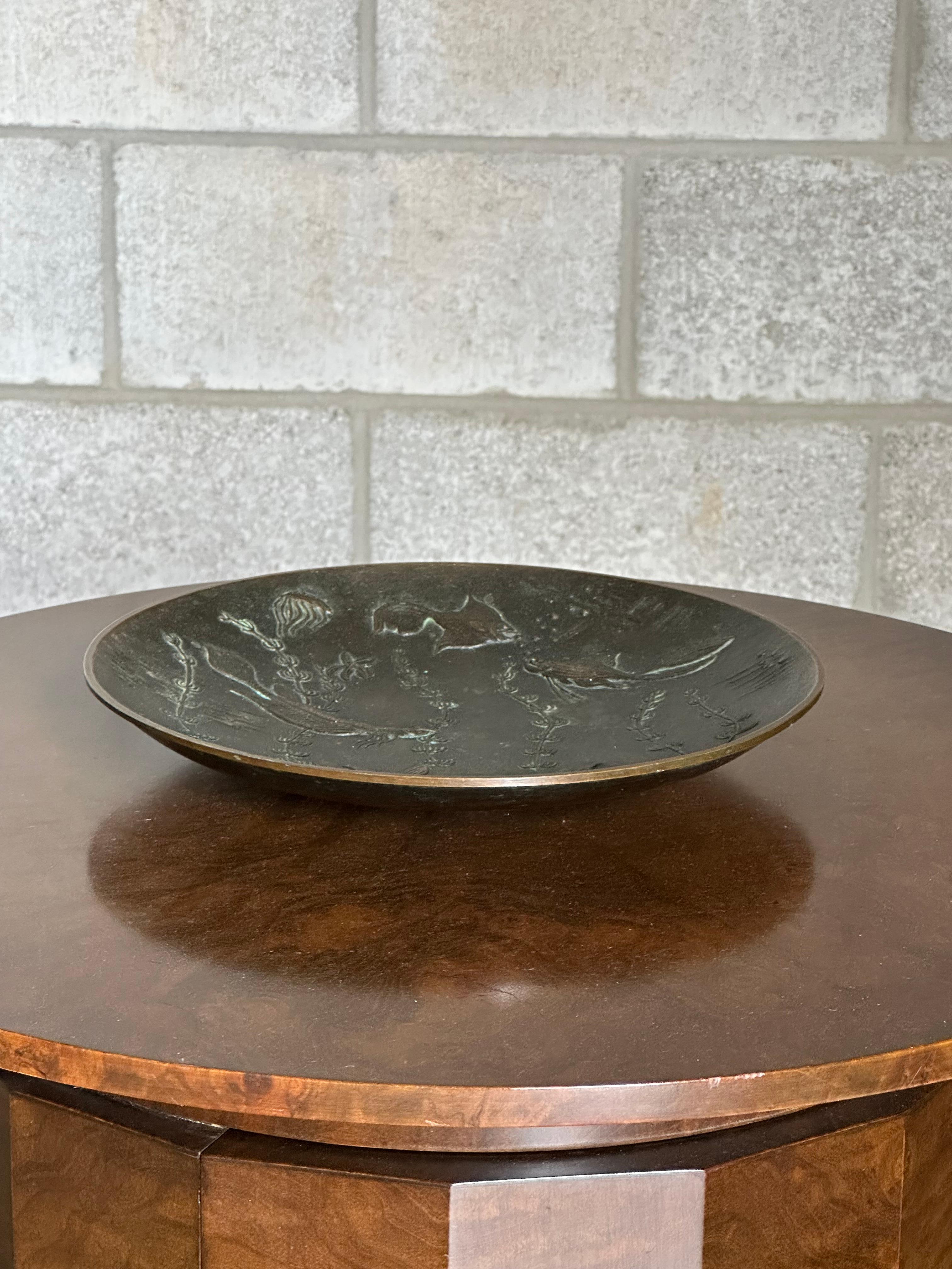 Una rara ciotola o piatto basso in bronzo massiccio disegnato da Gunnar Nylund per Akta Brons. Il pezzo presenta un motivo subacqueo con pesci. Patina e condizioni davvero meravigliose. Firmato GN sul fronte e 