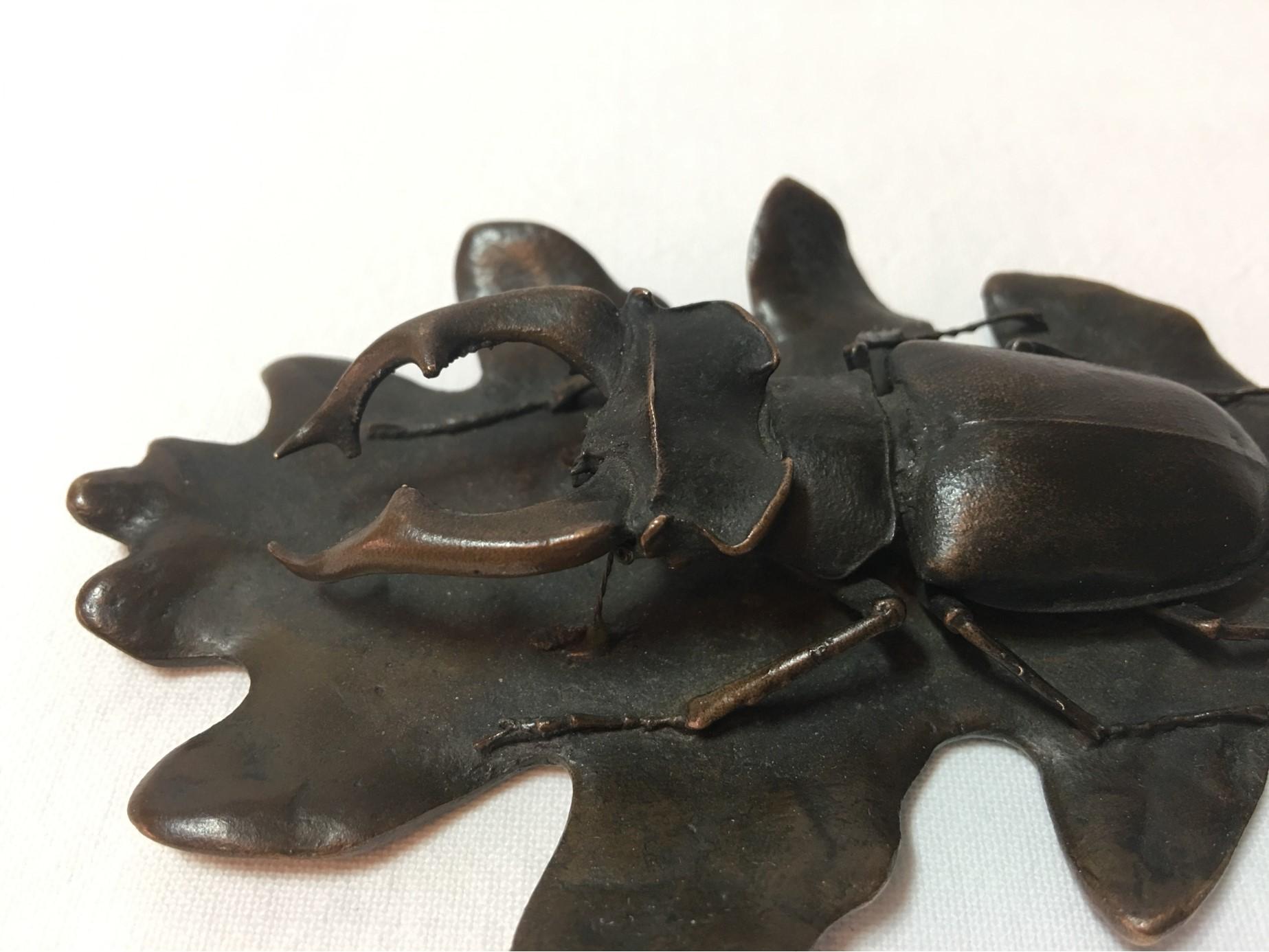 A rare item from circa 1900. A large bronze stag beetle on an oak leaf (