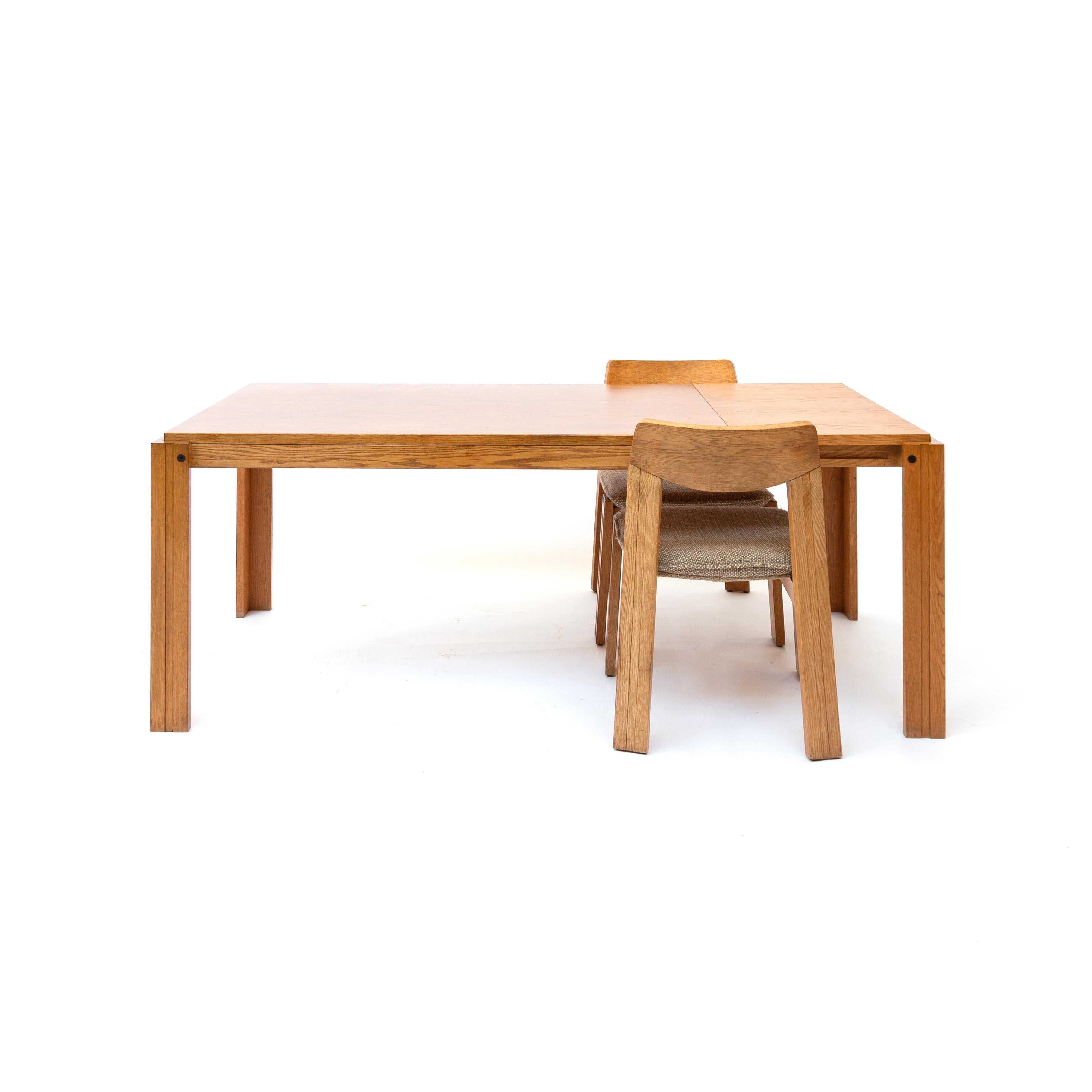 This Bluntly shaped oak dining table measures 184 x 90 cm in its standard shape. Its phenomenal sliding construction enables to add a 50 cm extra tableau. The thableau can invisible be stored underneath the fixed tabletop. The construction shown is