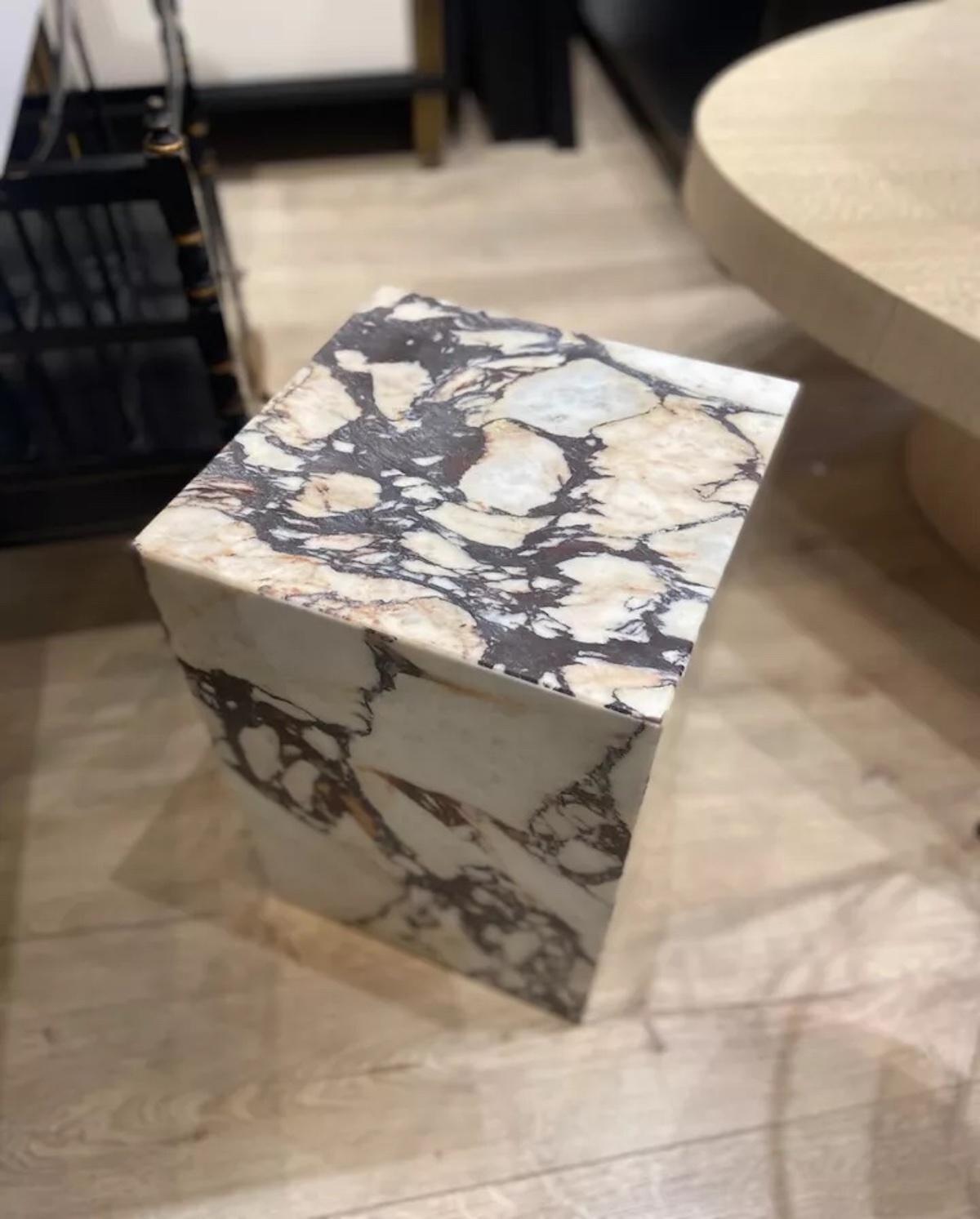 This stunning solid Calacatta Viola marble side table is a rare find, featuring exquisite veining that beautifully complements a variety of interior color schemes. Timeless in design, its substantial weight and rich color reflect exceptional