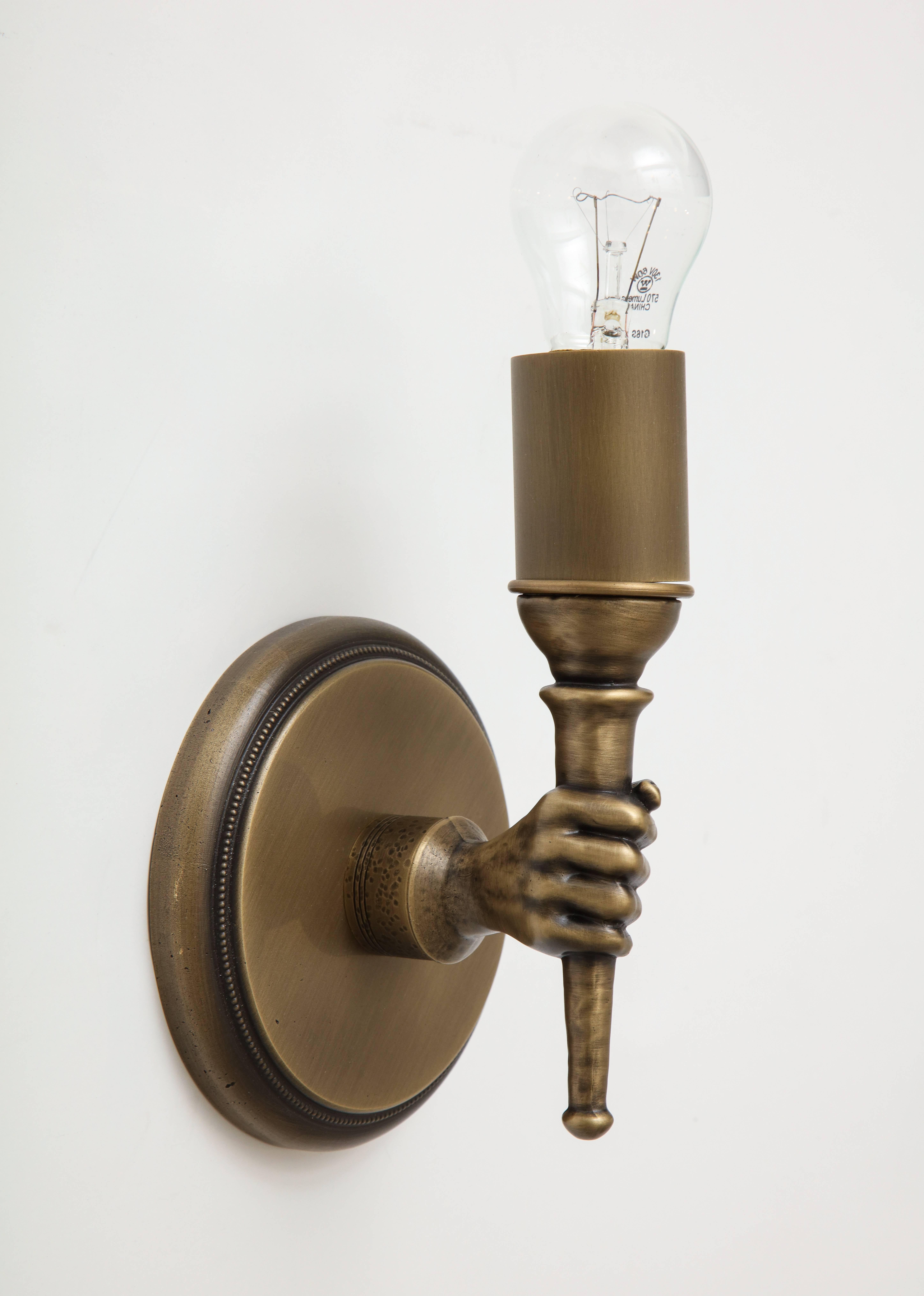 Solid cast, this whimsical yet elegant sconce is a perfect conversation piece for a hallway or powder room.

This fixture includes elements that have been hand-cast in an artisan studio.

Please note that pitting created in this classic technique is