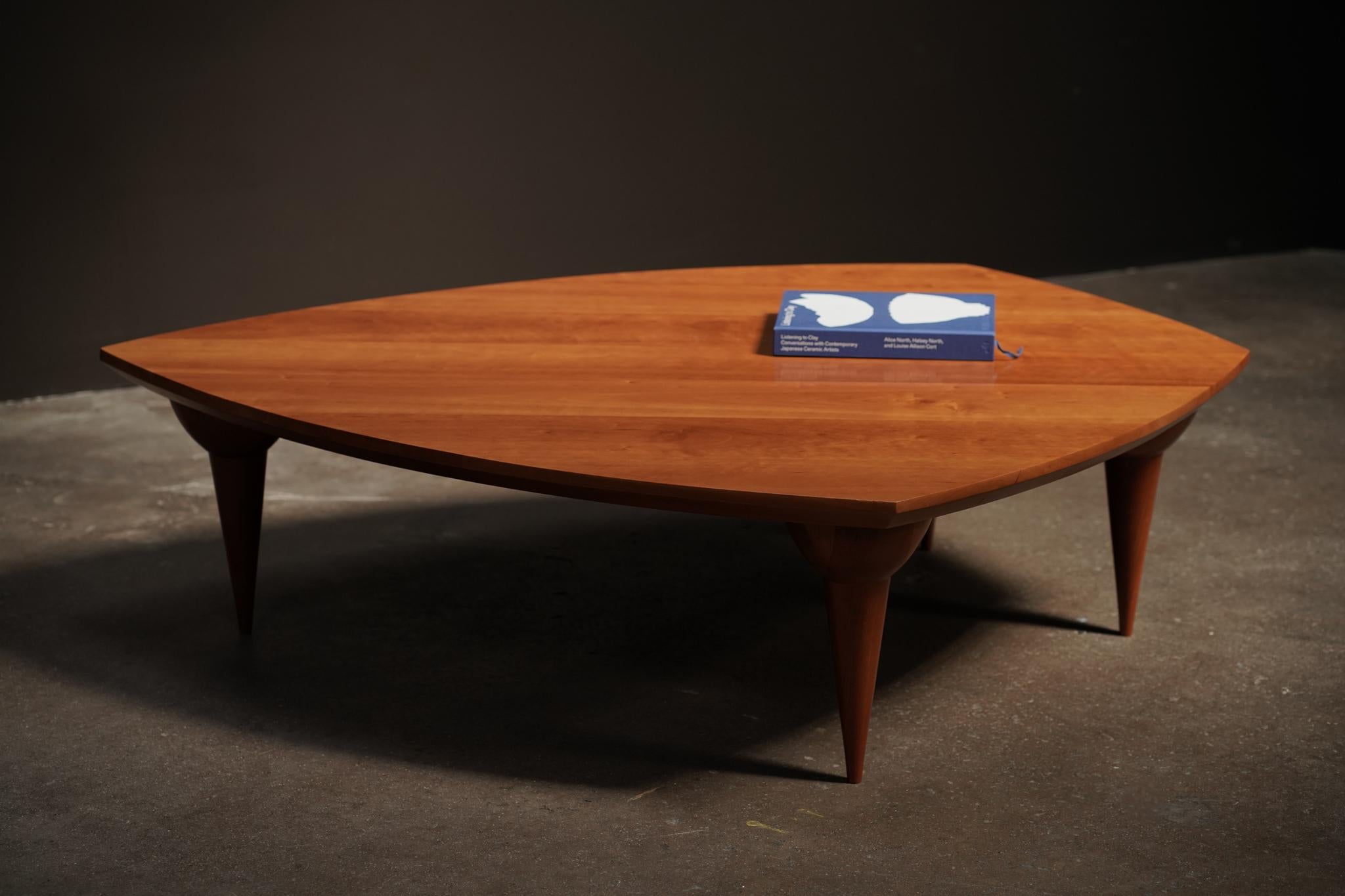 Mélange harmonieux d'artisanat et de design, cette table basse en bois de cerisier présente un placage riche et une élégance intemporelle. Créée par un artiste californien dans les années 1990, sa forme épurée et sa chaleur naturelle en font une