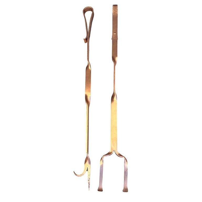 Ensemble d'outils de cheminée Art déco en cuivre massif fabriqué à la main, comprenant un tisonnier et des pinces. Chaque outil est formé à partir d'un morceau de cuivre plat qui a été façonné à la main pour obtenir un outil de forme