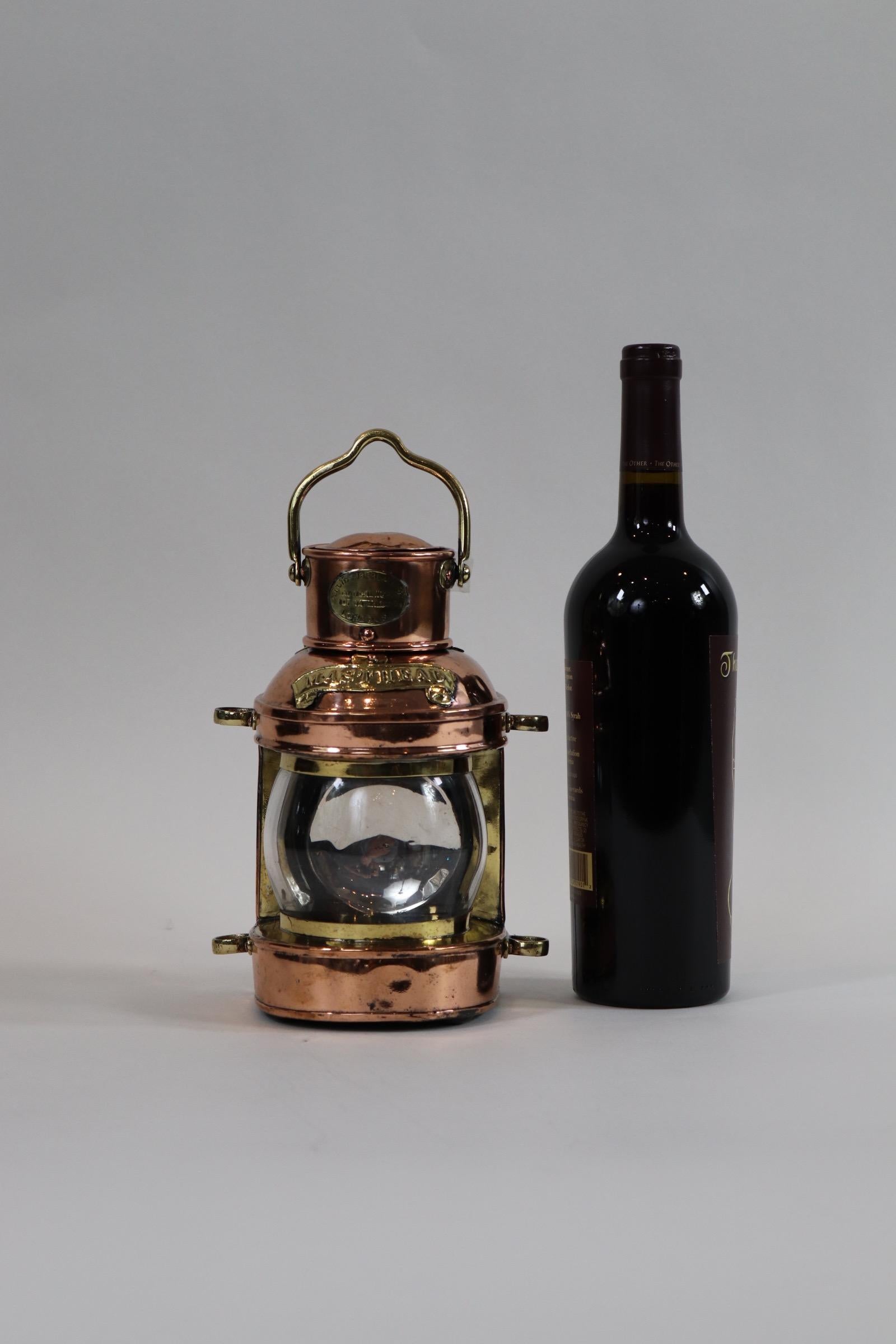 Copper with brass trim ships masthead lantern of English manufacture. Makers badge of Chamberlain of Waterloo, London. With glass lens. Tank with reflector. Polished and lacquered. Weight is 2 pounds.
