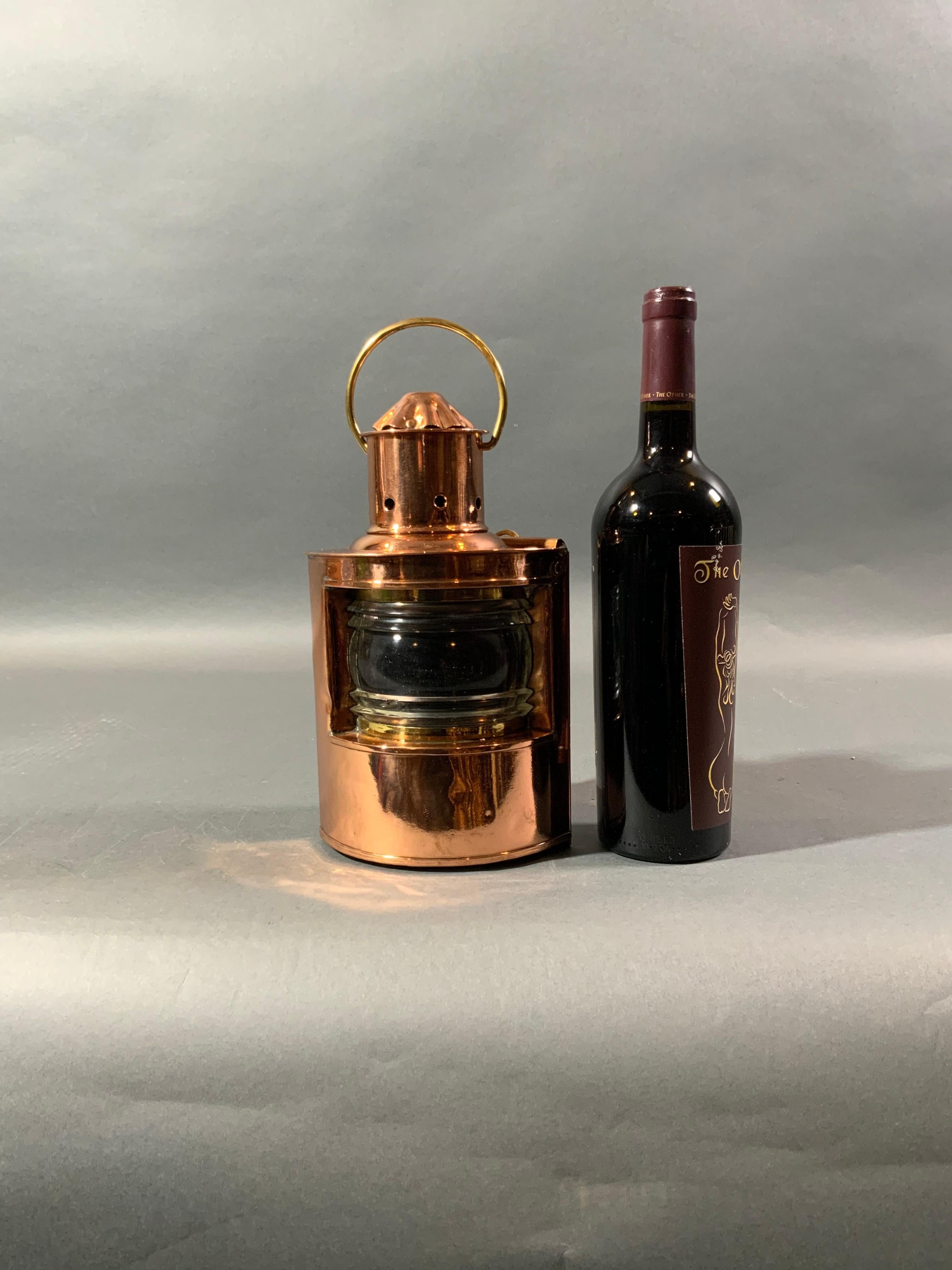 Solid copper ships lantern with Fresnel glass lens. No burner. With vented top, carry handle, and hinged door on rear. Note the flake to the lens. Weight 4 pounds. Dimensions 10 inches tall by 6 by 5. Price $395.