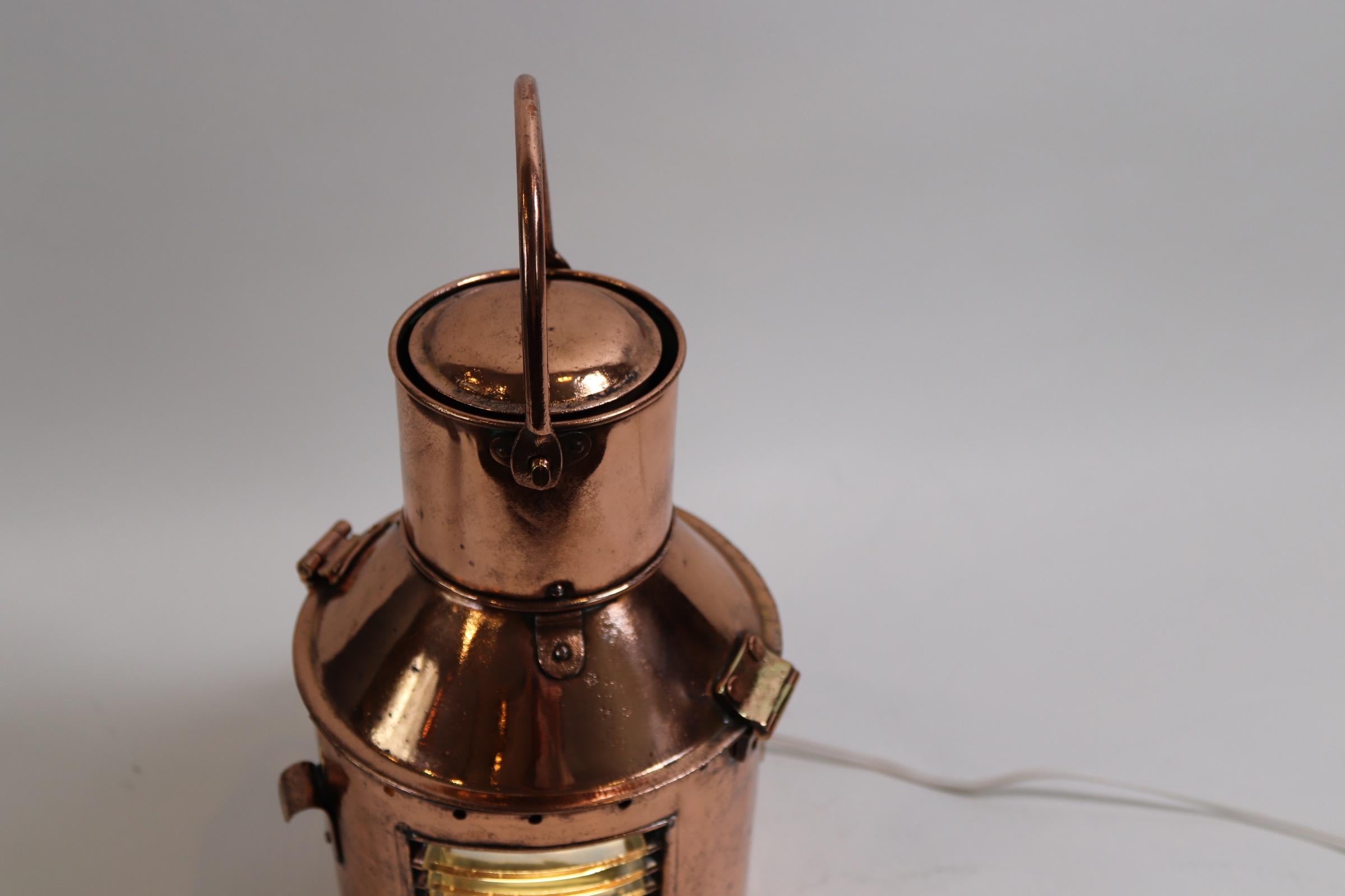 Solid copper ships signal lantern with hinged top, carry handle and fresnel lens. Wired for home use. Interior is missing the signal apparatus. Weight is 5 pounds.