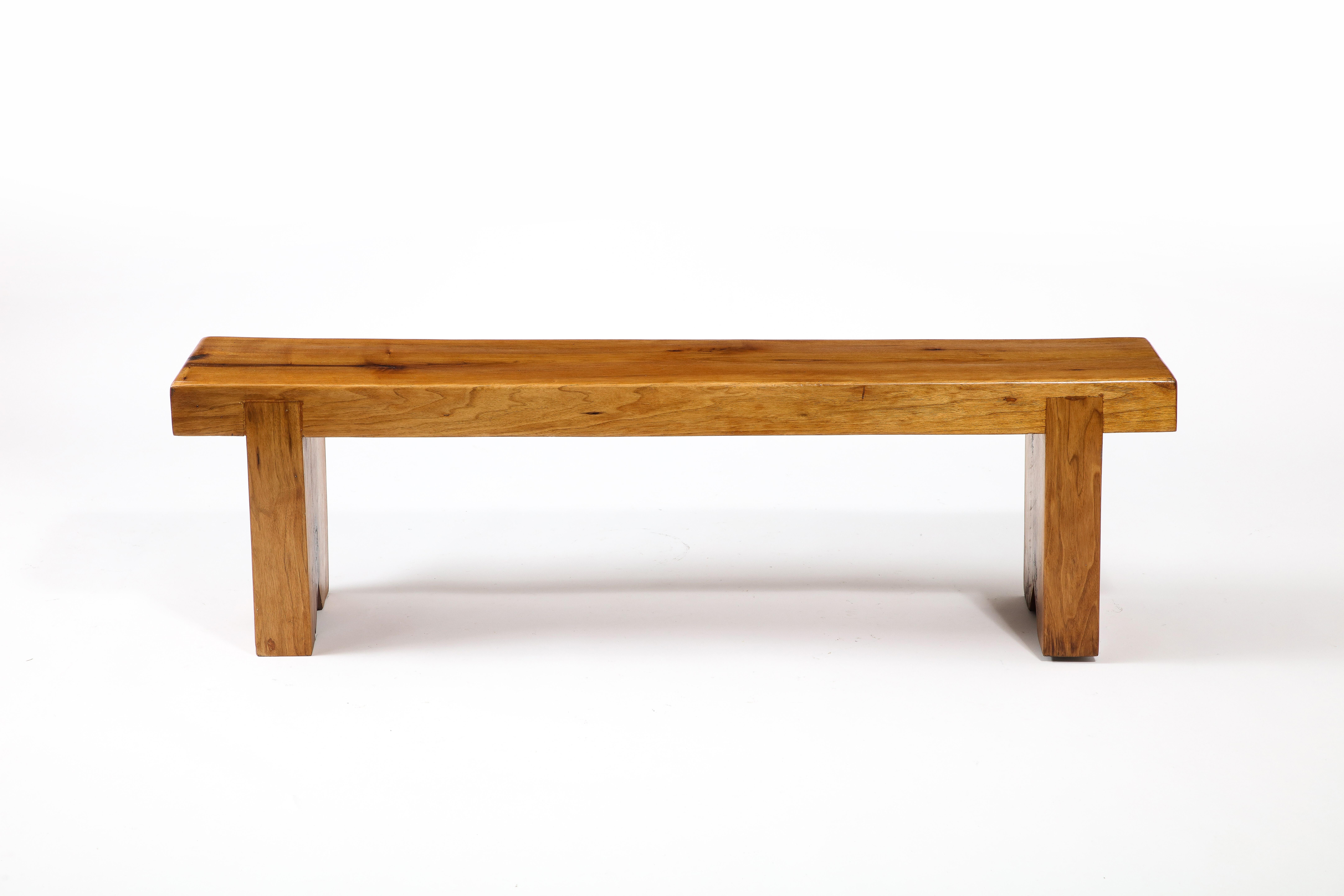 A solid Elm bench made of three parts with a large notched construction.