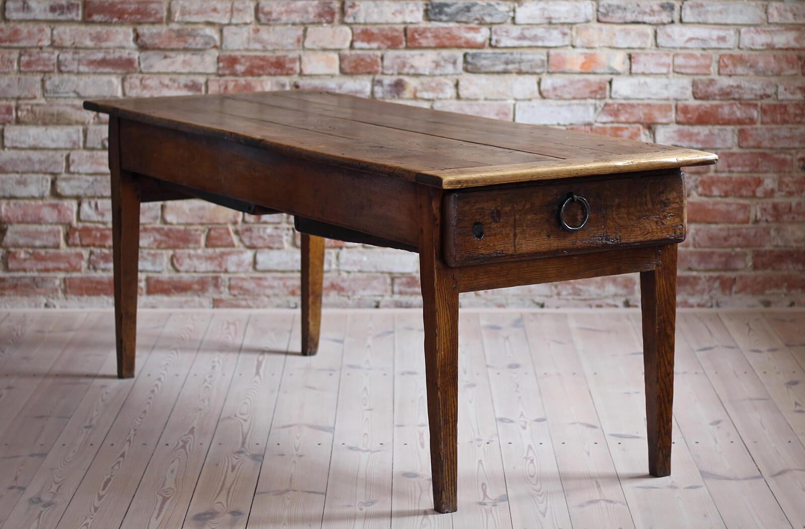 This gorgeous antique table was probably made in late 18th / Early 19th Century. It is made of elm wood. Two practical drawers reside in the table’s apron that allow for storage. Four wide elm boards comprise the table’s top. The piece was gently