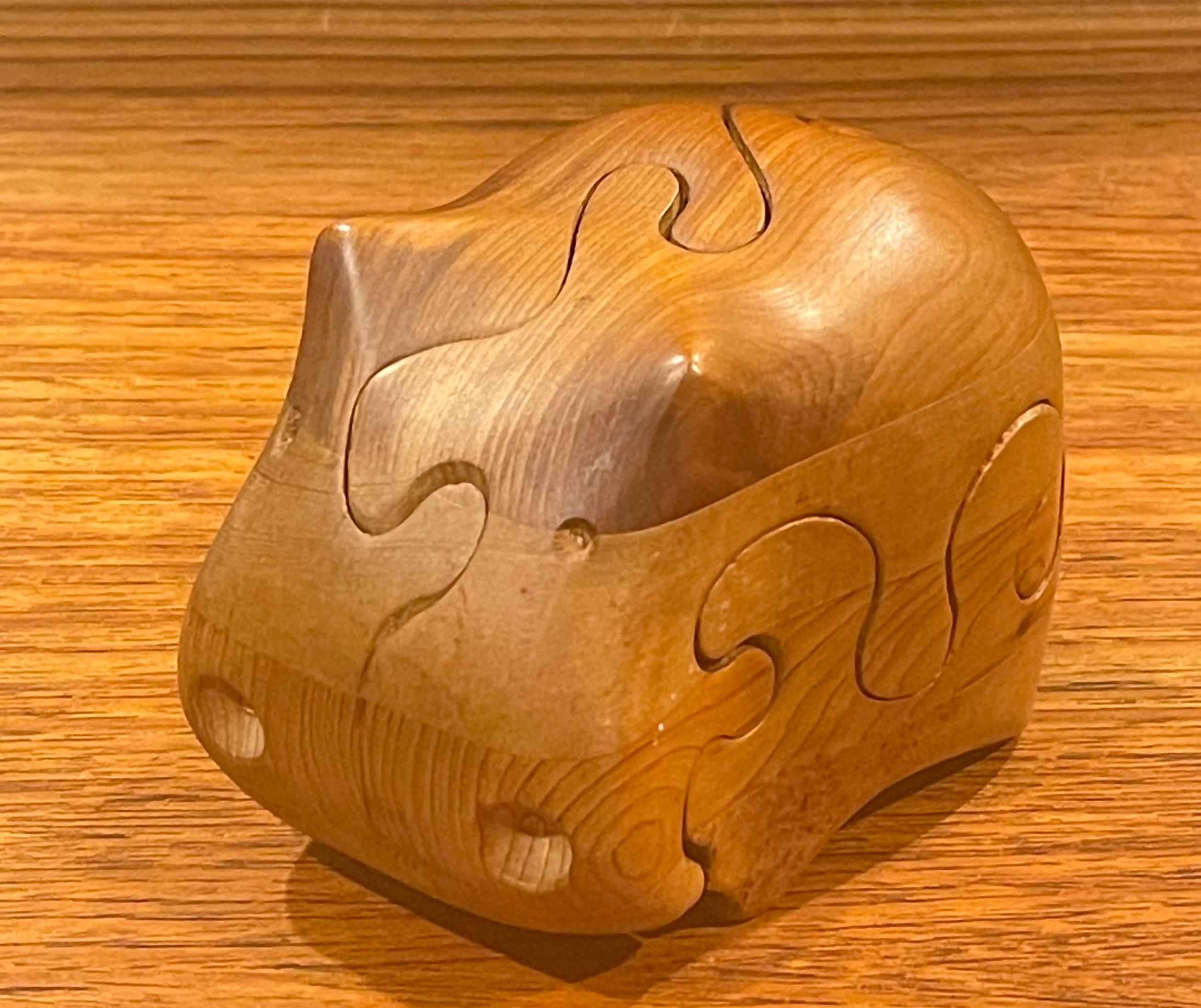 Incredible craftsmanship on this solid staved pine and cedar hippo puzzle / paperweight designed and hand crafted by artist Deborah Bump, circa 1970s. The piece is in very good vintage condition and measures 3.25