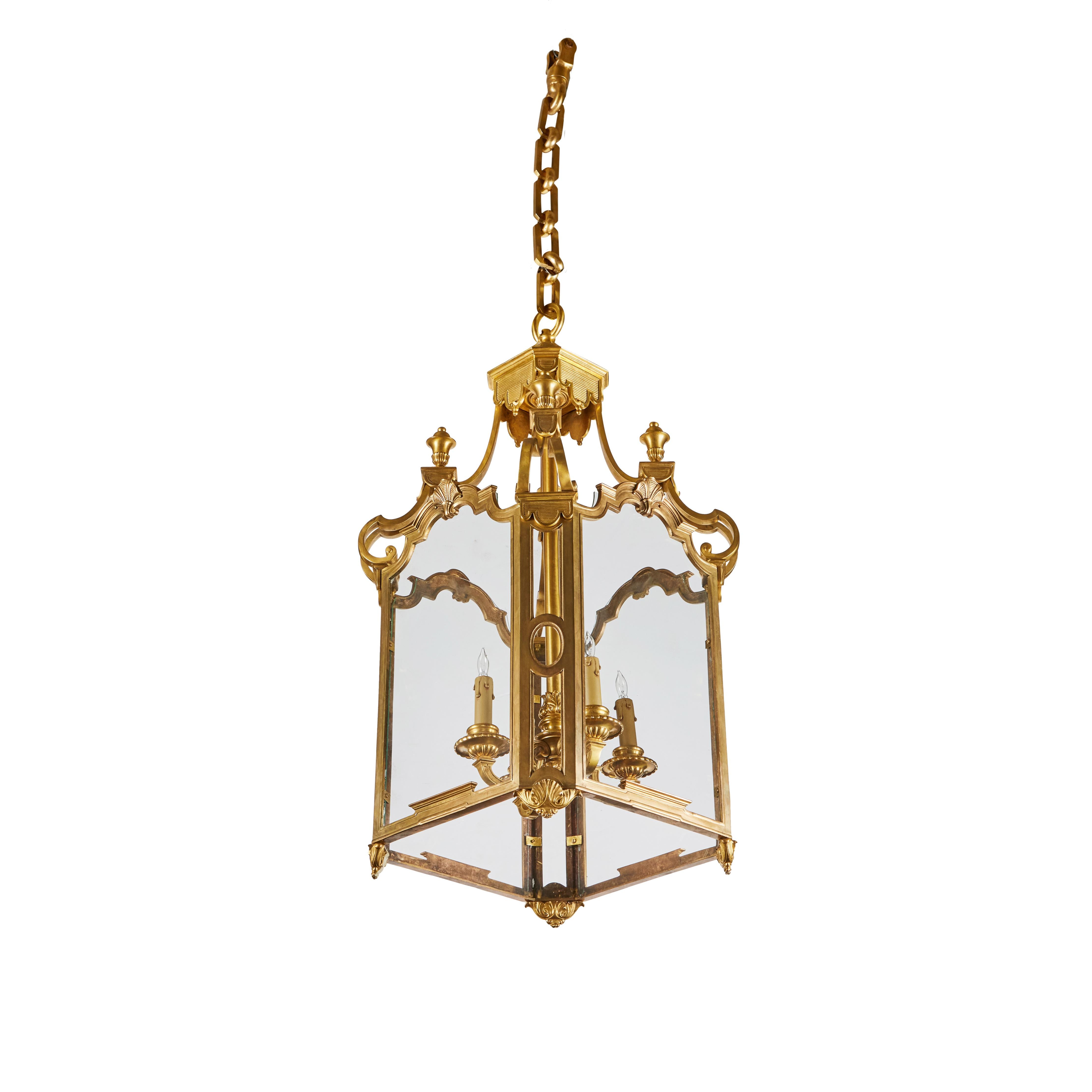Elegante farol macizo de bronce dorado y cristal, de 4 luces, con cadena a juego.