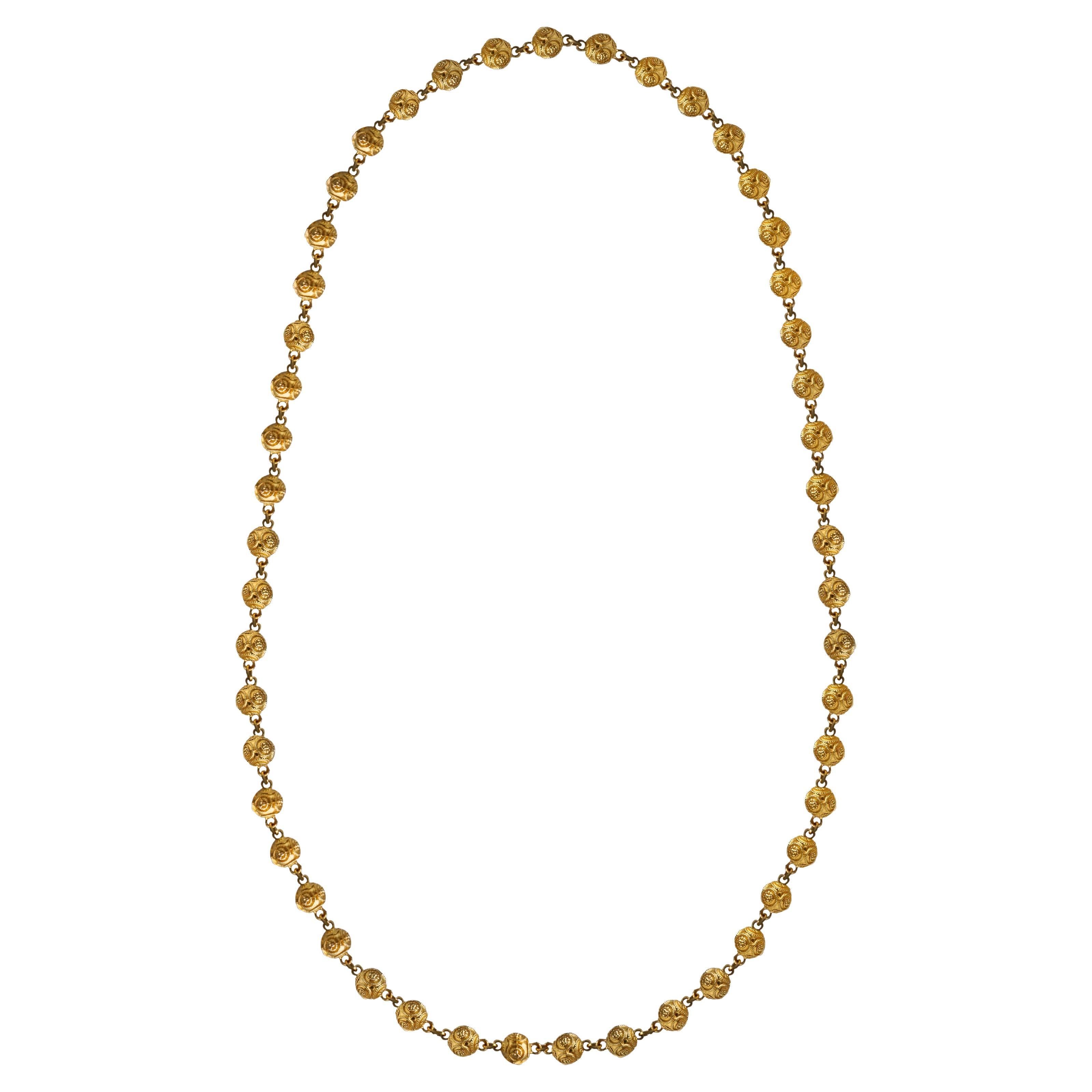 Collier boule en or massif 18K de style néo-étrusque. Un design unique relie 51 boules en or jaune dans un anneau à ressort ovale sans fermoir ouvert.
Dimensions de la boule d'or : 7,48 mm de long x 9 mm de large.
Dimensions du collier : 32