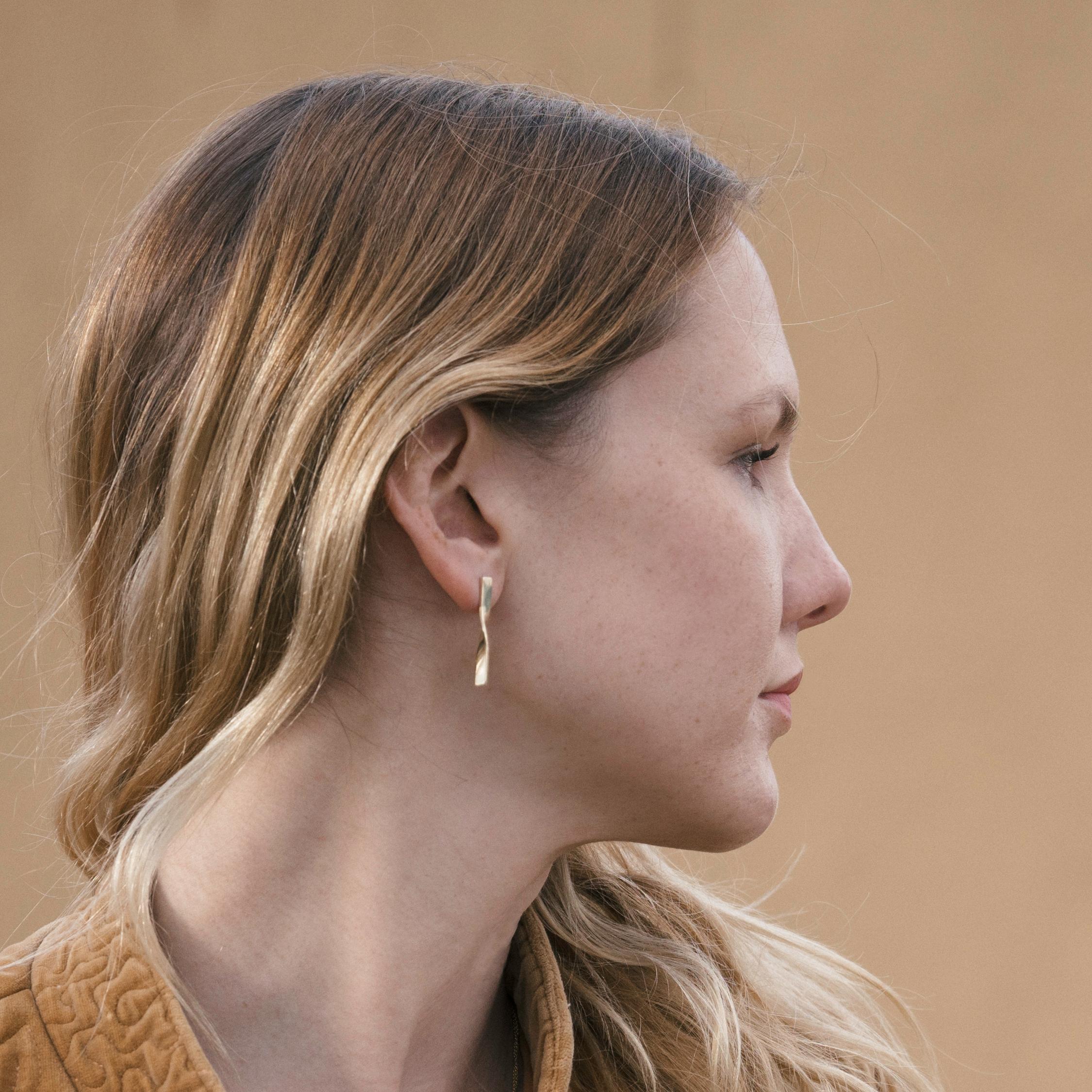 The Shift Earrings taper and twist in unison as they make a graceful quarter turn. The two earrings mirror each other and can be interchanged to reverse their orientation to the face. Their subtle transformation is an ode to shifting perspectives.