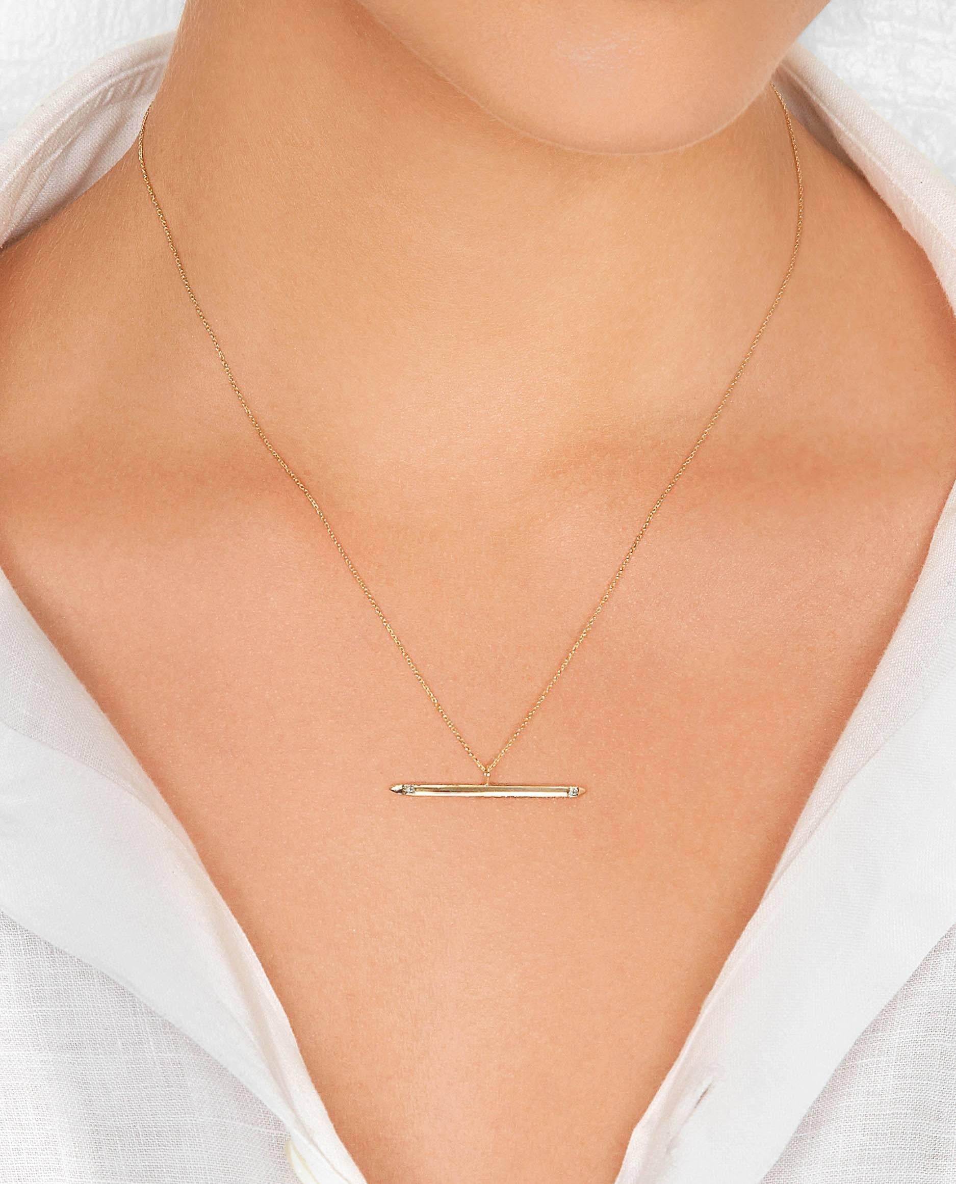 This spear-shaped pendant is crafted in 9-carat yellow gold accented with two white diamonds and strung on a fine 16-inch gold chain. The total diamond carat weight is 0.016 carats of H/VS1 quality diamonds and the pendant is 2mm in width by 35mm in