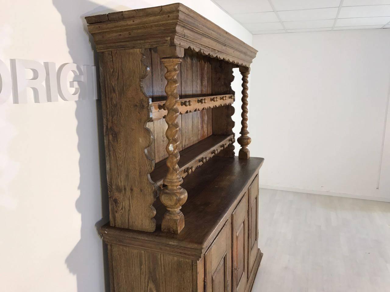 A solid cane cabinet. Striking are the beautiful ornaments above and the twisted columns on the sides. The waxed oak gives the piece a special old-fashioned touch. The piece includes original locks and keys which are in a good condition. With the