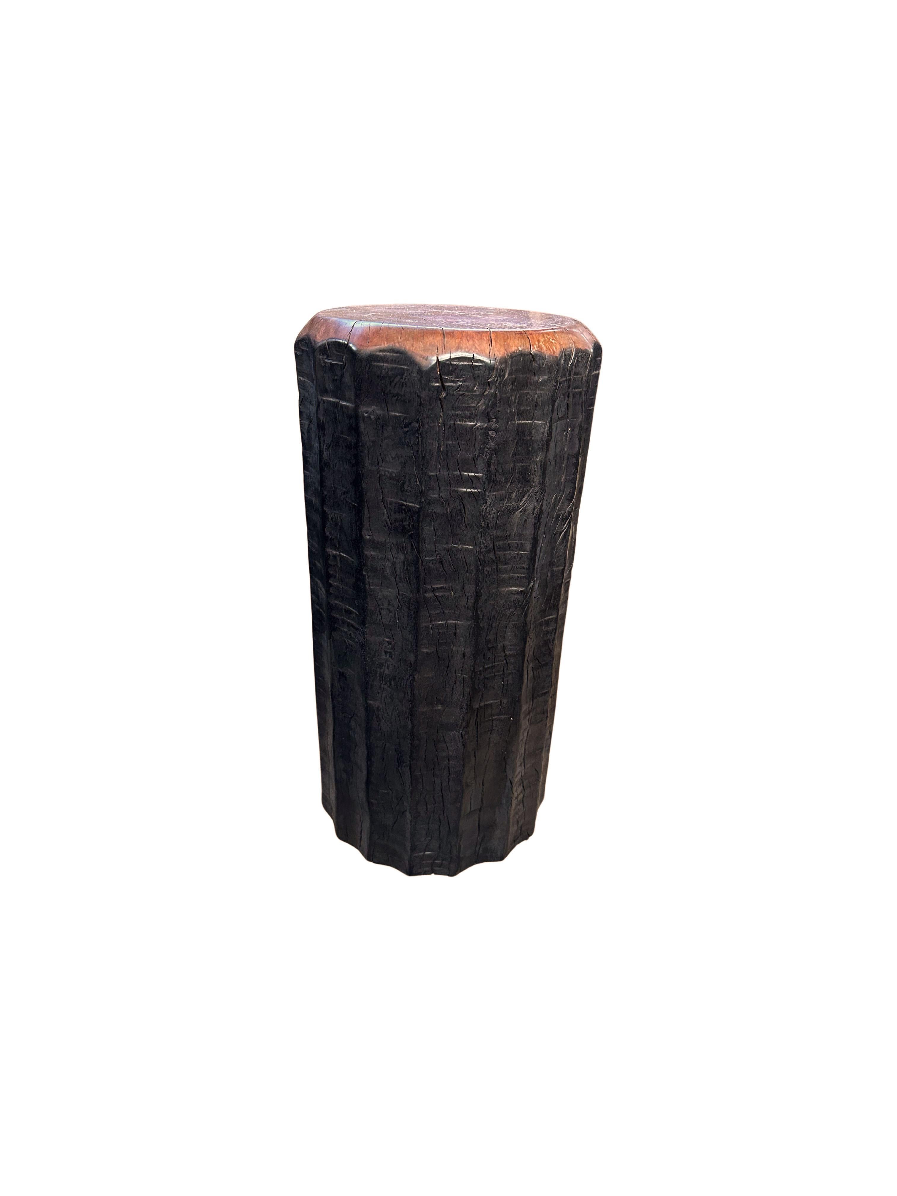 Une table d'appoint ronde merveilleusement sculpturale. Ses pigments neutres lui permettent de s'adapter à tous les espaces. Il a été fabriqué à partir d'un bloc massif de bois de litchi et présente des détails sculptés sur ses côtés. Les textures