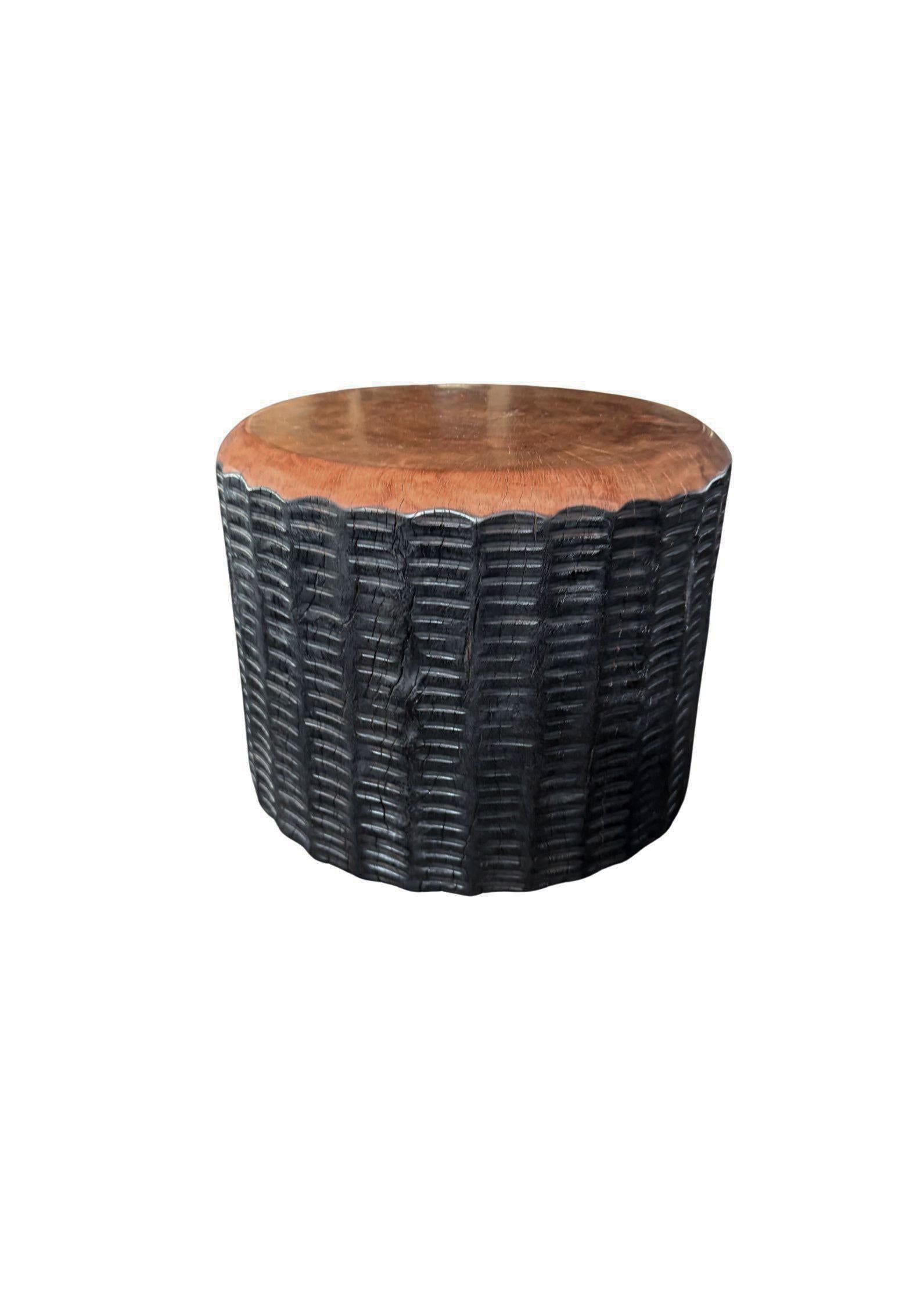 Une table d'appoint ronde merveilleusement sculpturale. Ses pigments neutres lui permettent de s'adapter à tous les espaces. Il a été fabriqué à partir d'un bloc massif de bois de litchi et présente des détails sculptés sur ses côtés. Les textures