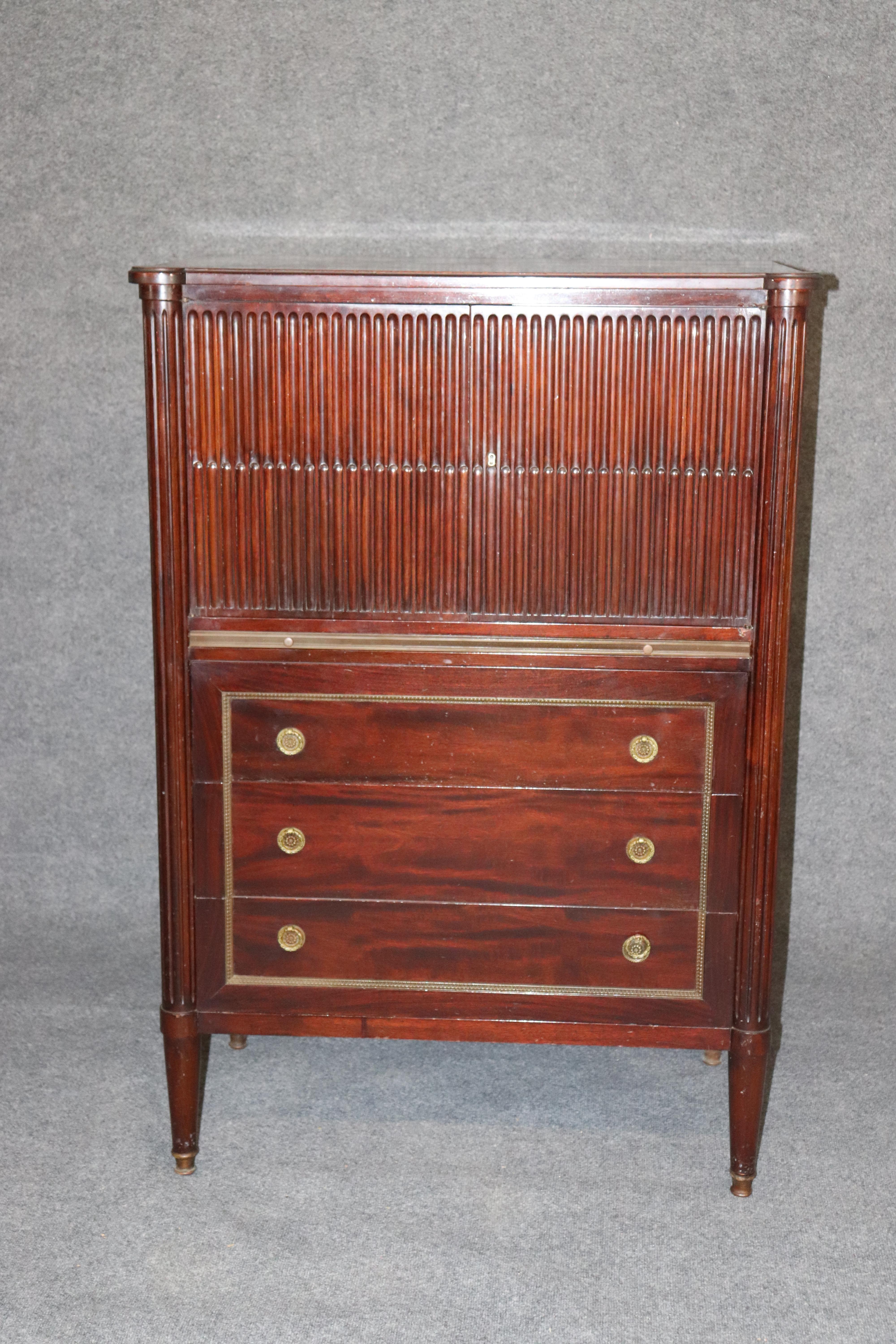 This is a gorgeous and well made French Directoire style Dresser made in the 1940s era. It features a gold tooled leather embossed pull out tray for neckties and cufflinks. The dresser also has brass trim and sophisticated lines. Measures 52.75 tall