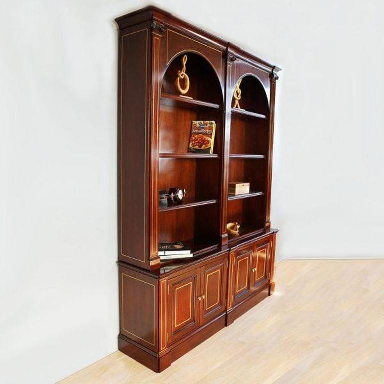 A refined statement in classical design, this English-style bookcase is meticulously crafted from solid mahogany and enriched with elegant brass inlay throughout. Its twin arch-top display shelves create striking symmetry, framed by hand-carved