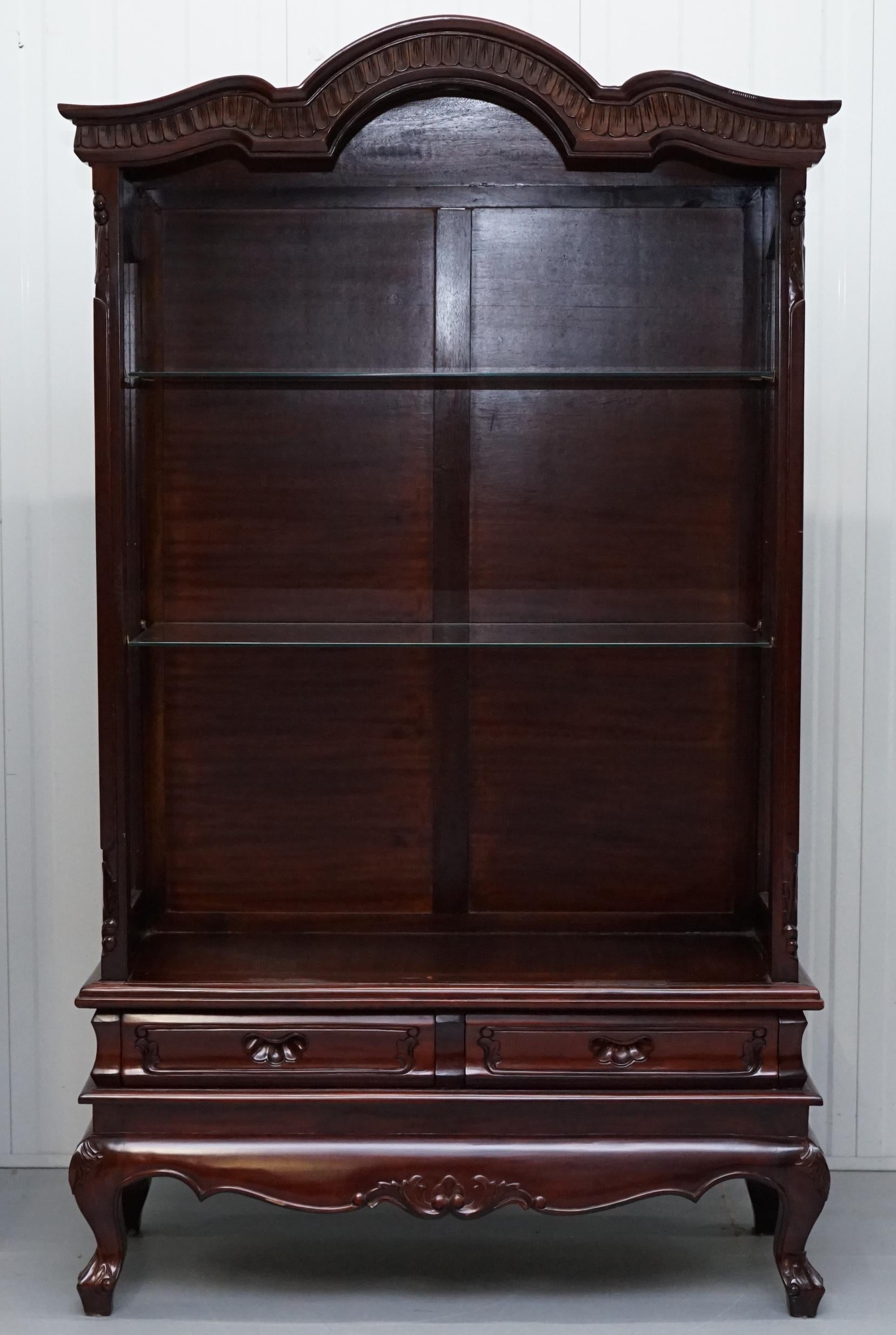 We are delighted to offer for sale this lovely ornately carved solid Mahogany glass shelved display cabinet

A well-made piece of furniture that looks amazing from every angle

We have cleaned waxed and polished it from top to bottom, the