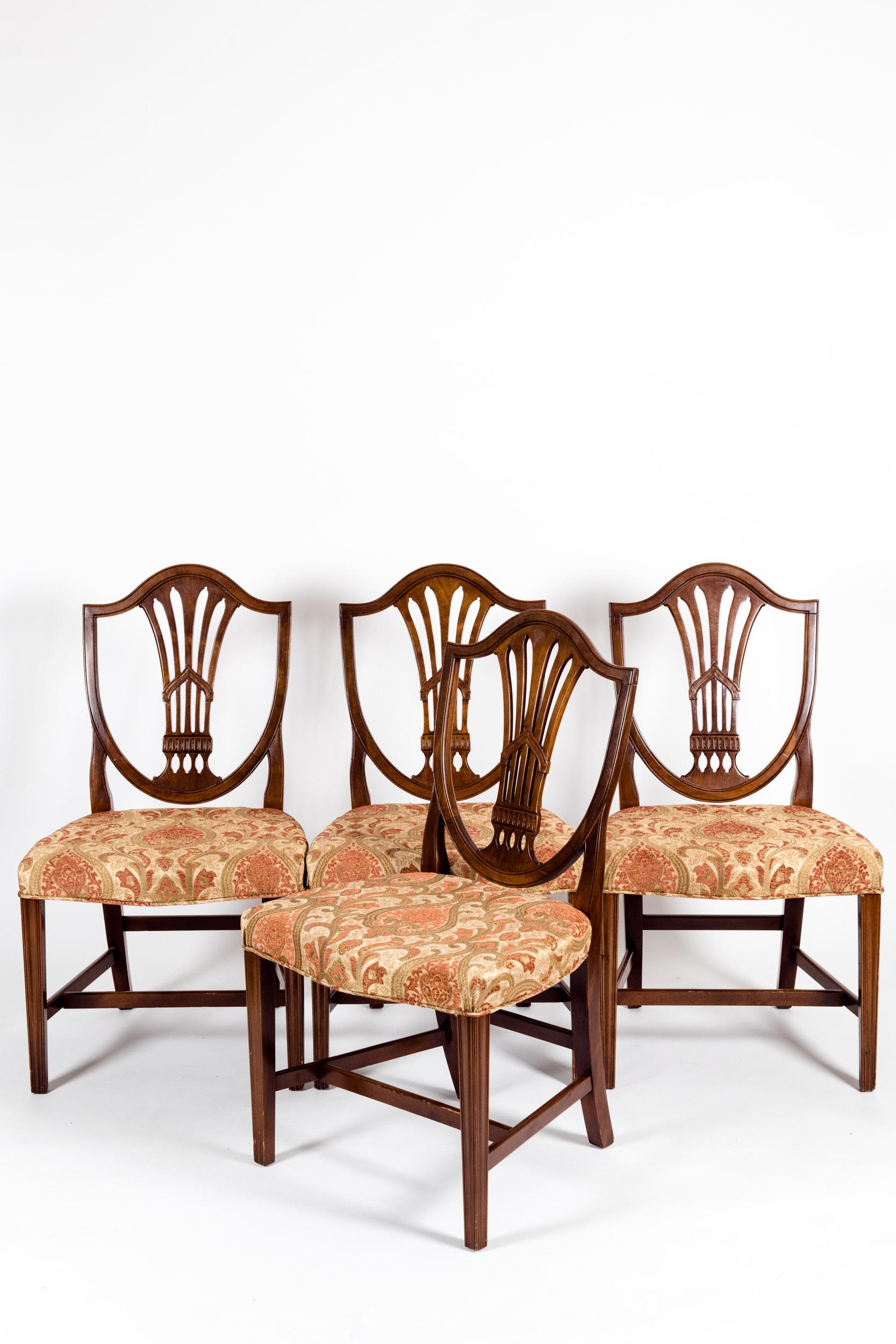 Solid mahogany wood shield back set of four dining chairs. Each chair is in excellent vintage sturdy condition. Minor wear consistent with use / age. Very immaculate upholstery. American craftsmanship, early 20th century. Each chairs measure about