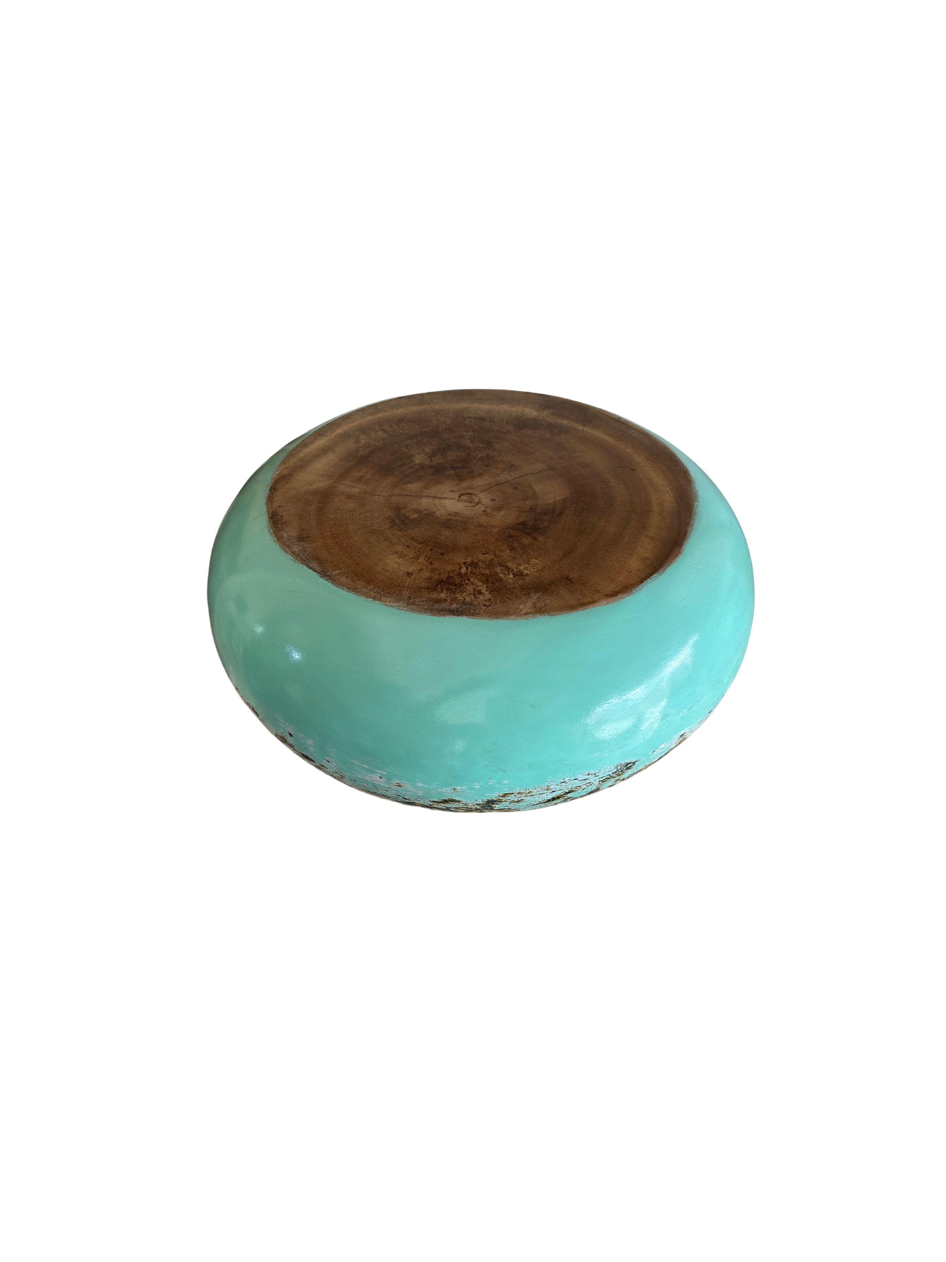 A hand-crafted mango wood bowl. The bowl was cut from a much larger slab of mango wood and features a hand painted detailing on its sides that is then sanded down to achieve a unique texture. The bowl is then completed with a clear coat. It