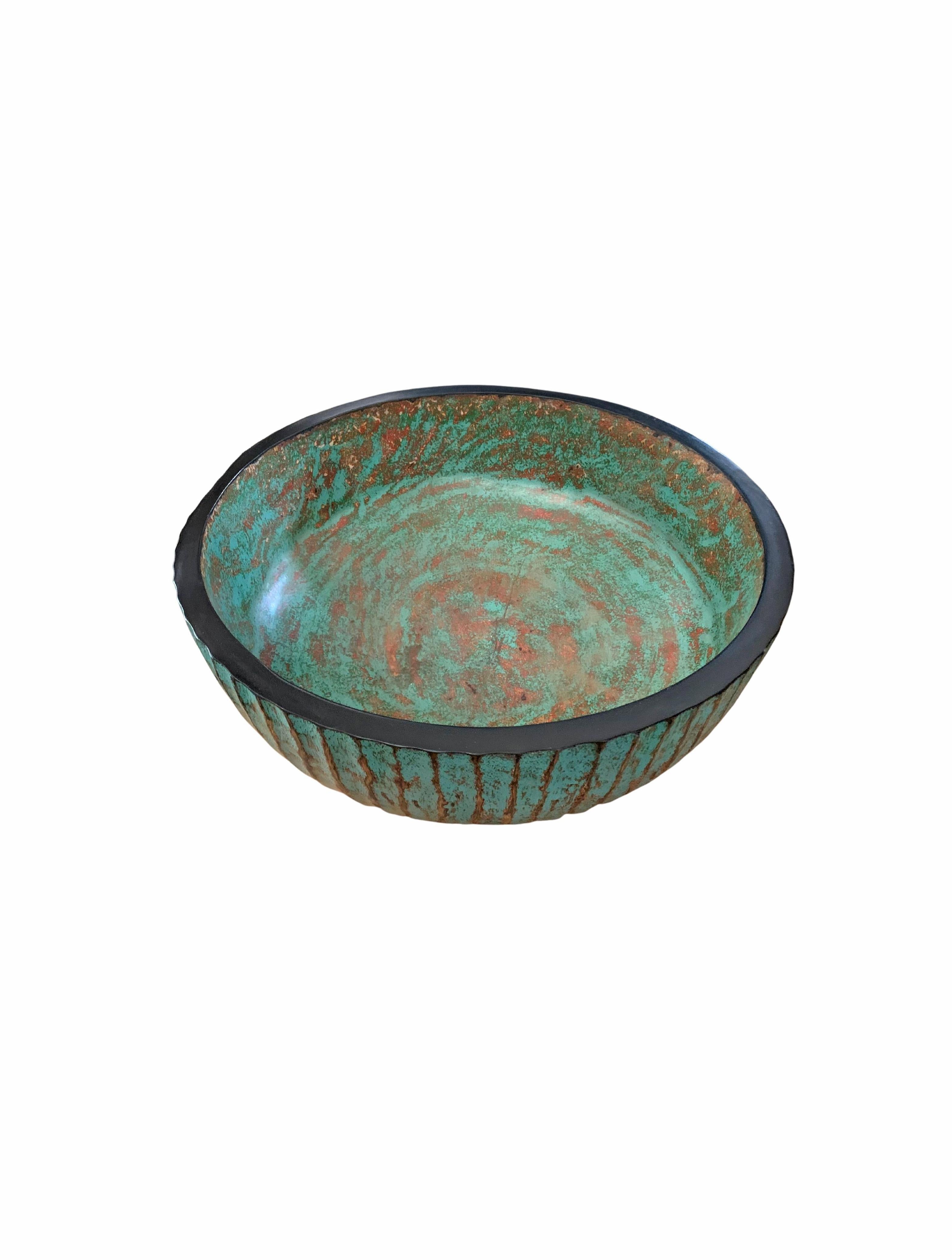 A hand-crafted mango wood bowl. The bowl was cut from a much larger slab of mango wood and features a ribbed texture on its sides. It features a wonderful turquoise pigment that is then sanded down to achieve a unique texture. The bowl is then