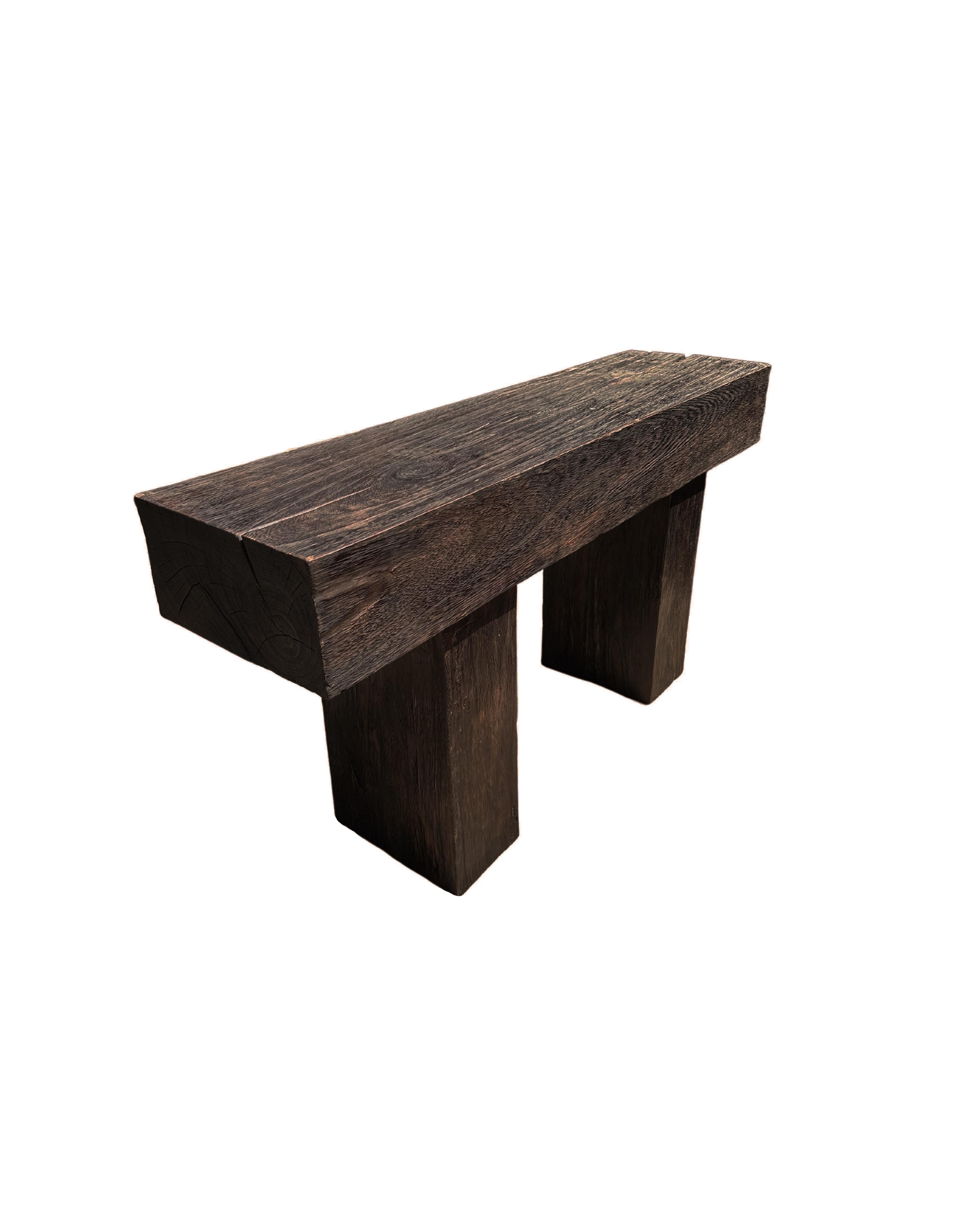 A sculptural mango wood console table crafted from solid mango wood. The table top sits atop two solid,  legs. A wonderfully minimalist object. The subtle wood textures present on all sides adds to its charm. To achieve its unique pigment the wood