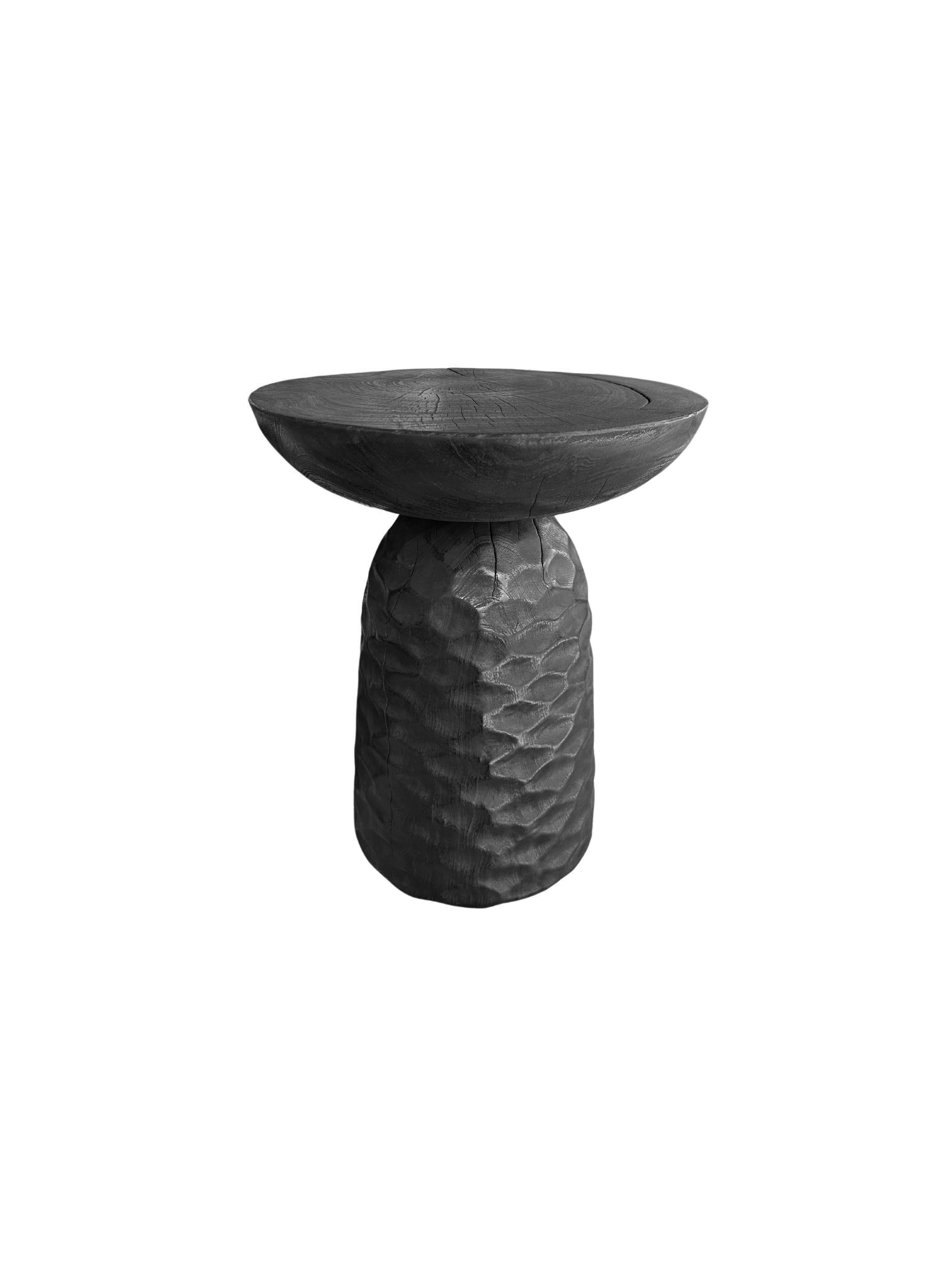 A wonderfully sculptural round side table, with an hourglass shape. Its neutral pigments make it perfect for any space. A uniquely sculptural and versatile piece certain to invoke conversation. It was crafted from a solid block of mango wood and has