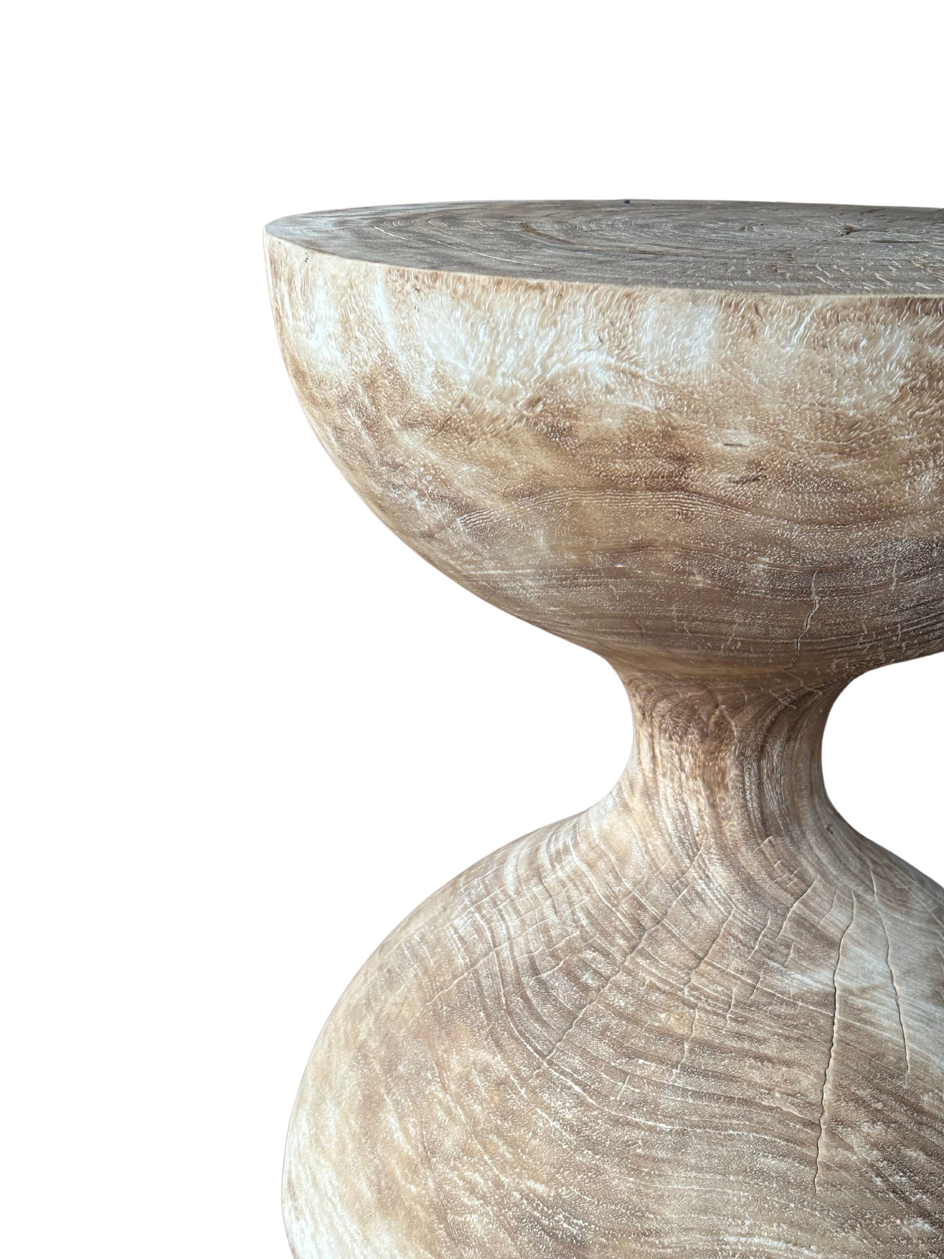 Une table d'appoint ronde merveilleusement sculpturale, en forme de sablier. Ses pigments neutres lui permettent de s'adapter à tous les espaces. Une pièce sculpturale unique et polyvalente qui ne manquera pas de susciter la conversation. Il a été