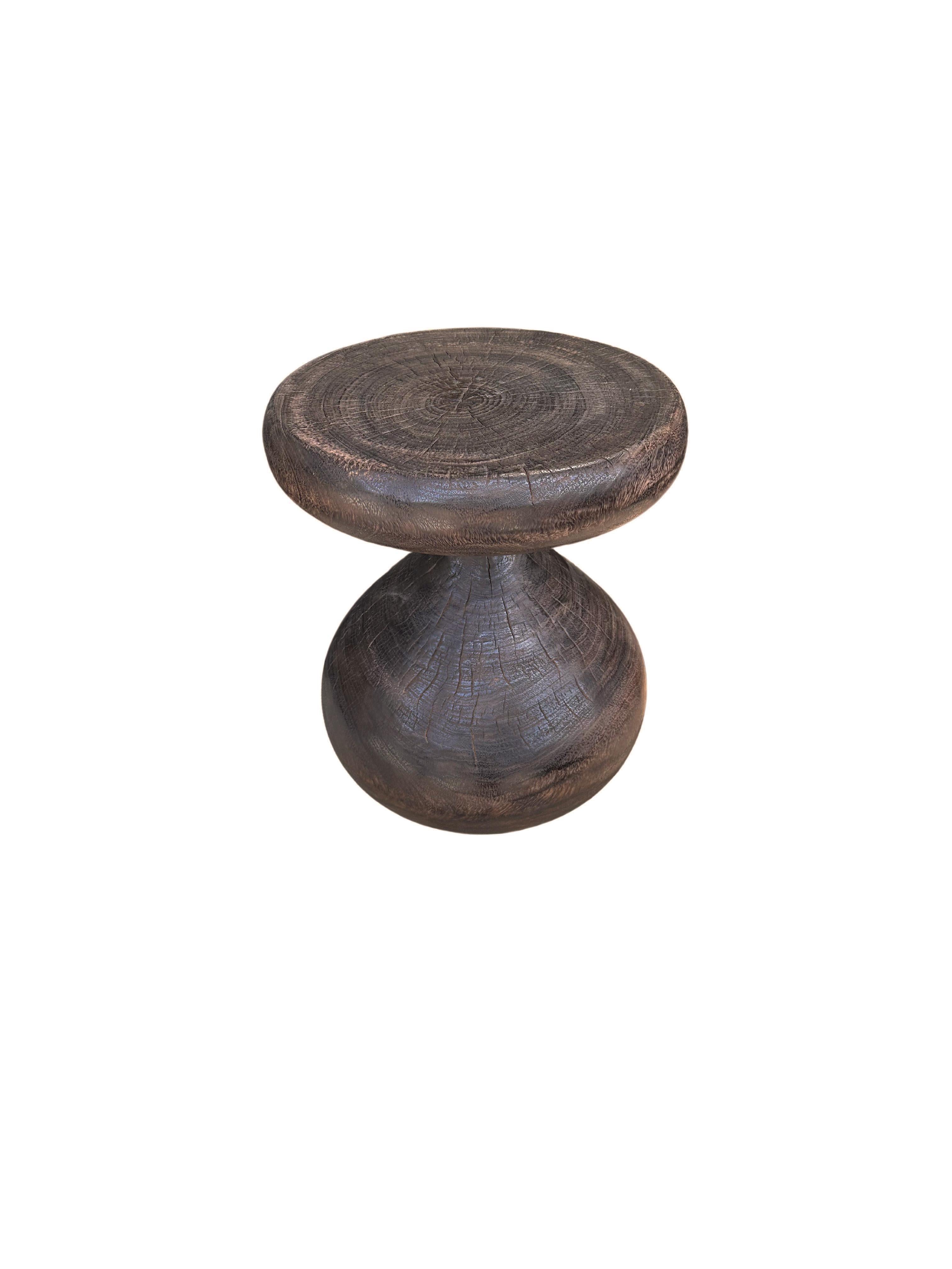 Une table d'appoint ronde merveilleusement sculpturale, en forme de sablier. Ses pigments neutres lui permettent de s'adapter à tous les espaces. Une pièce sculpturale unique et polyvalente qui ne manquera pas de susciter la conversation. Il a été