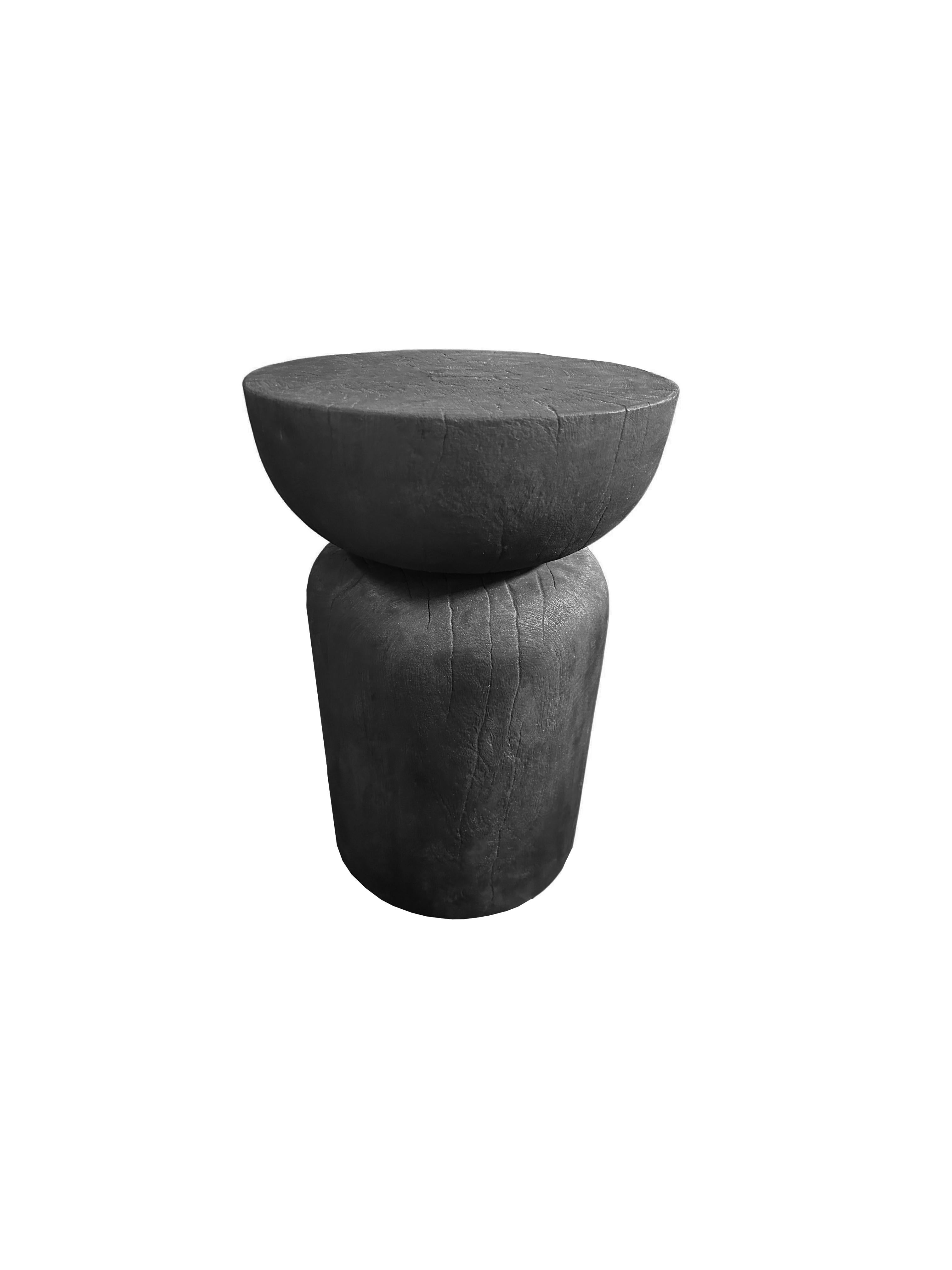 A wonderfully sculptural round side table. Its neutral pigments make it perfect for any space. A uniquely sculptural and versatile piece certain to invoke conversation. It was crafted from a solid block of mango wood and has a smooth texture burnt